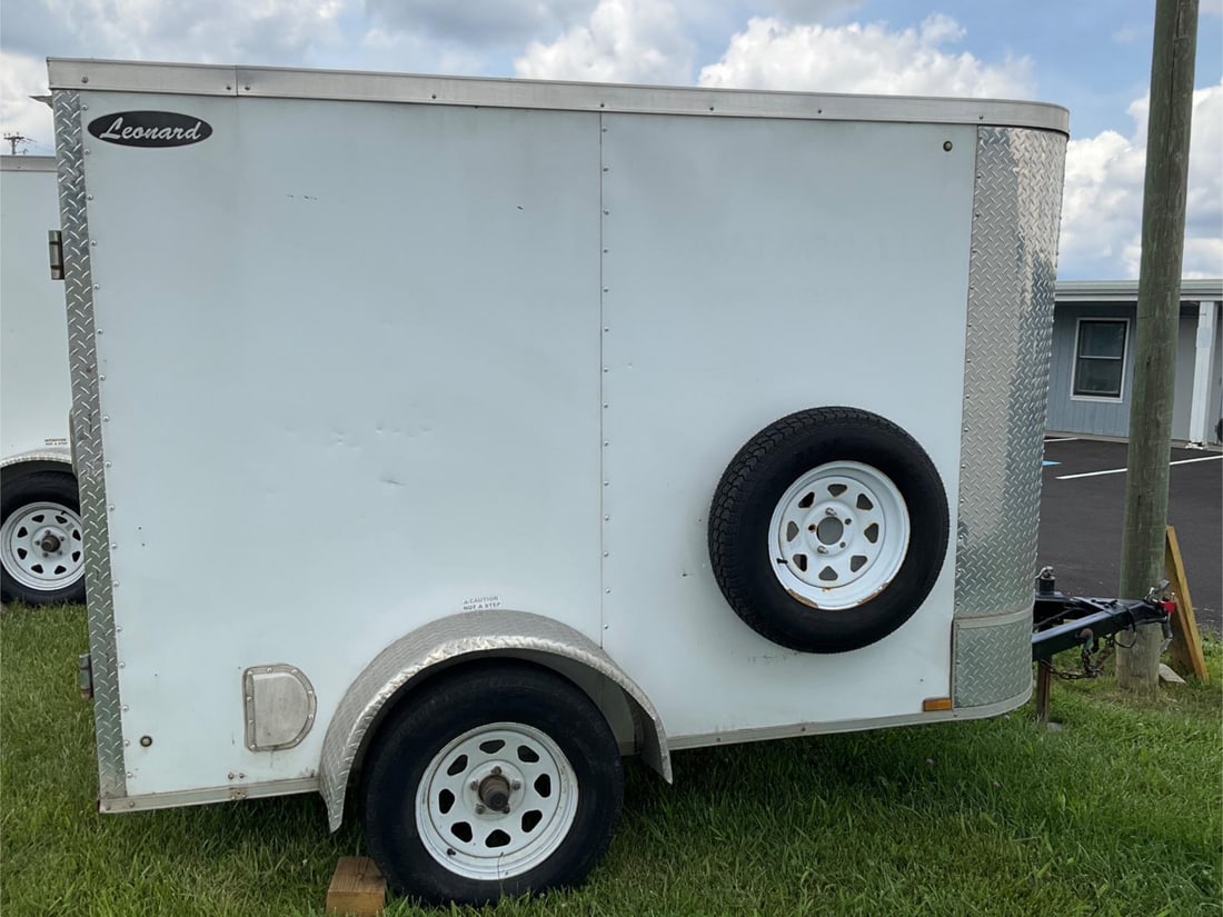 Leonard Trailer: 2018 Enclosed, white, Leonard 5’x8’ pull behind rounded V-Nose single axel trailer. Model number 58VSDW. Inside has been fitted with custom wood shelving for tools, parts, etc. Spare tire is