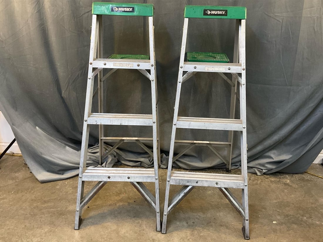 Huskey Step Ladders: Two Huskey 4 ft. aluminum 225 lb. load capacity ladders with paint /tool tray shelf. Used, good working condition. One ladder with a broken aluminum paint tray support. Measures 14.5 inches wide x 5