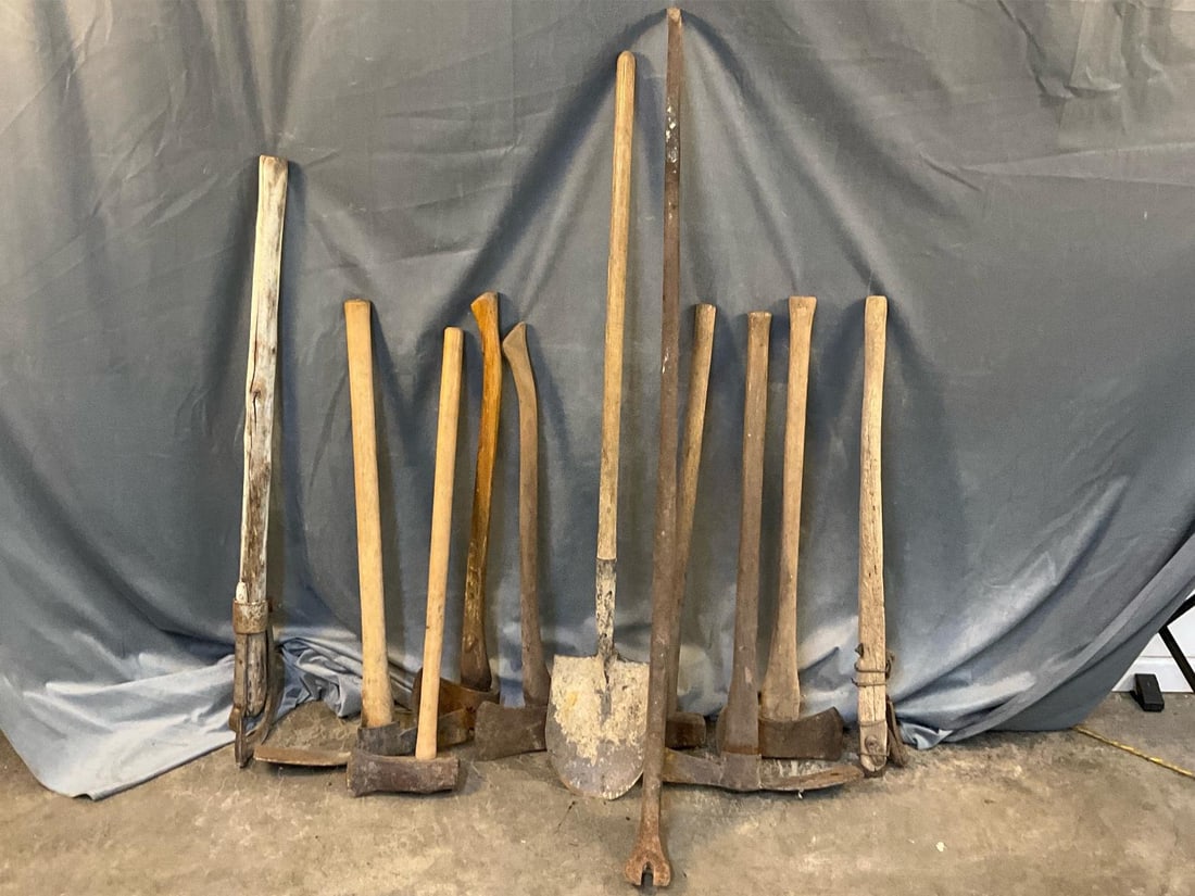 Assorted Farm Tools: Eleven construction/farming hand tools. Heavy iron pry bar, Maddox, axes, shovel, wedges and log roller plus more. Surface rust, used condition. Pry bar measures 8.5 inches wide x 3.25 x 59 inches
