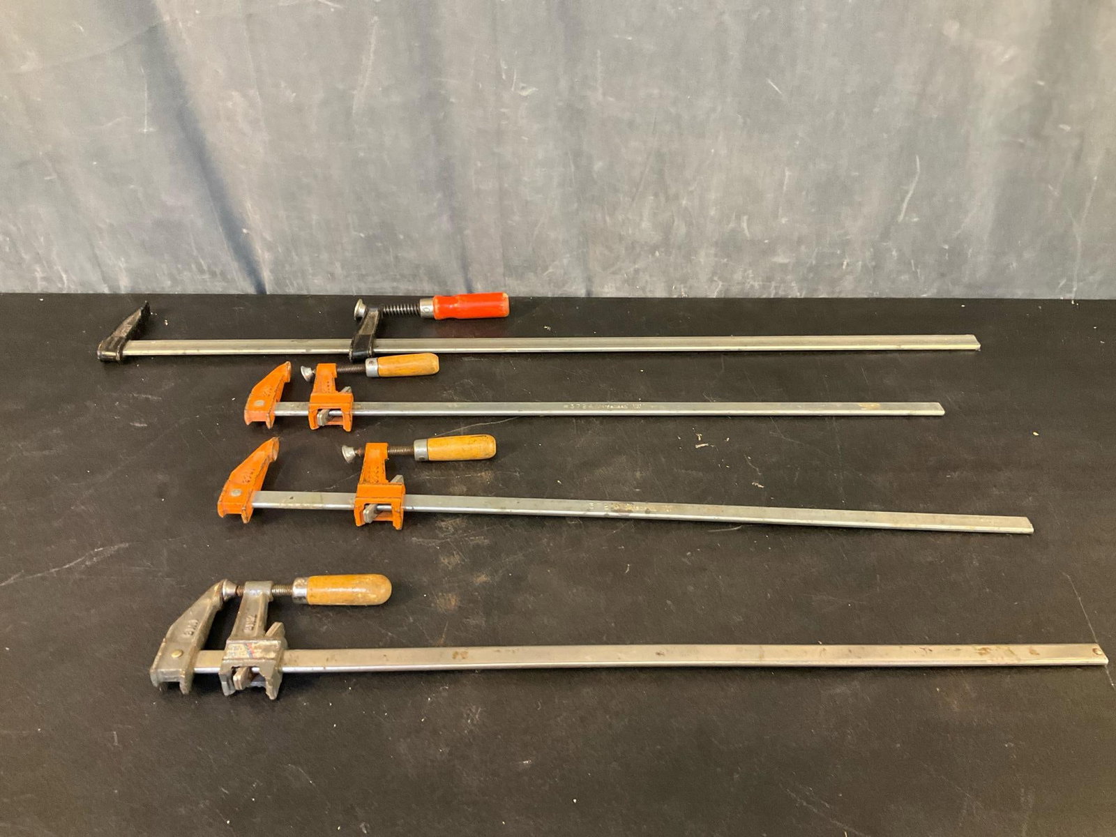 Woodworking Bar Clamp: Four woodworking metal bar clamps. Good used condition. Largest measures 38 inches, three measure 28 inches.
