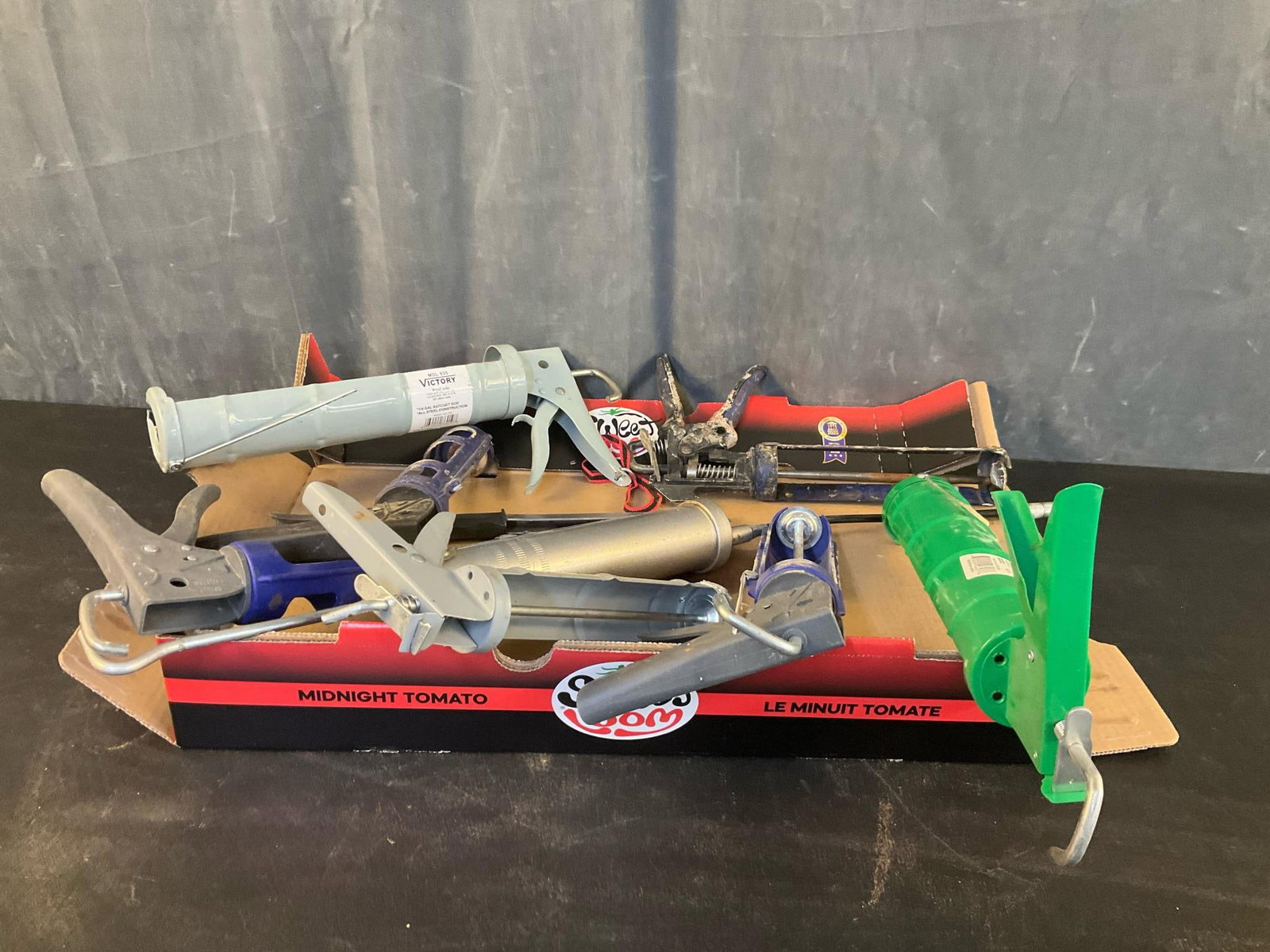 Caulk Guns: Seven caulk guns and one grease gun. Used condition. Standard qt. size gun measures 18 inches wide x 3 x 7 inches tall.