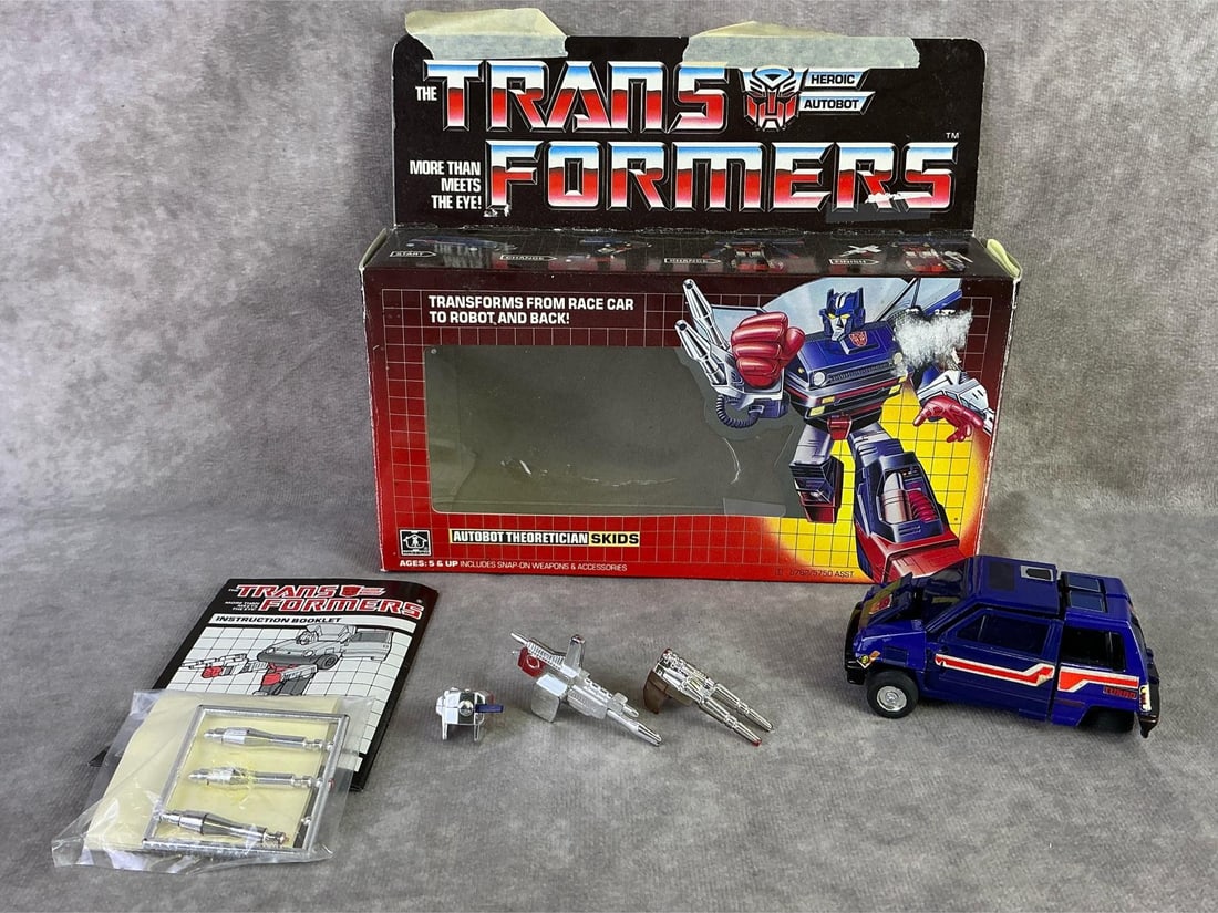 Skids Transformer: 1984 Transformers, Skids Autobot Theoretician made by Hasbro, Japan. In fair condition with original box, has been opened, missing tire, creasing and bowing to box. Measures 8.5 inches wide x 7.15
