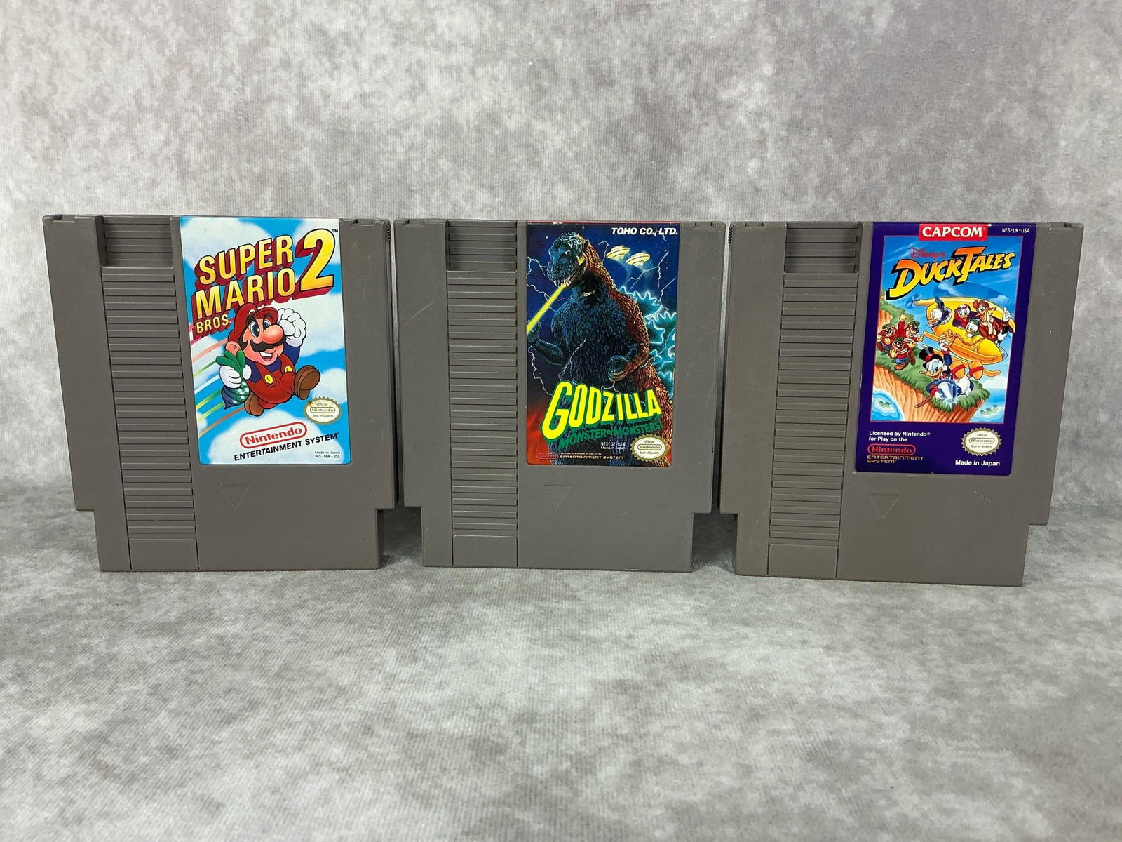 Nintendo Games: Three vintage Nintendo NES games made in Japan. Includes Godzilla, Super Mario 2, and Duck Tales. All games are untested, good condition. Each one measures 4.75 inches wide x 5.25 inches tall.