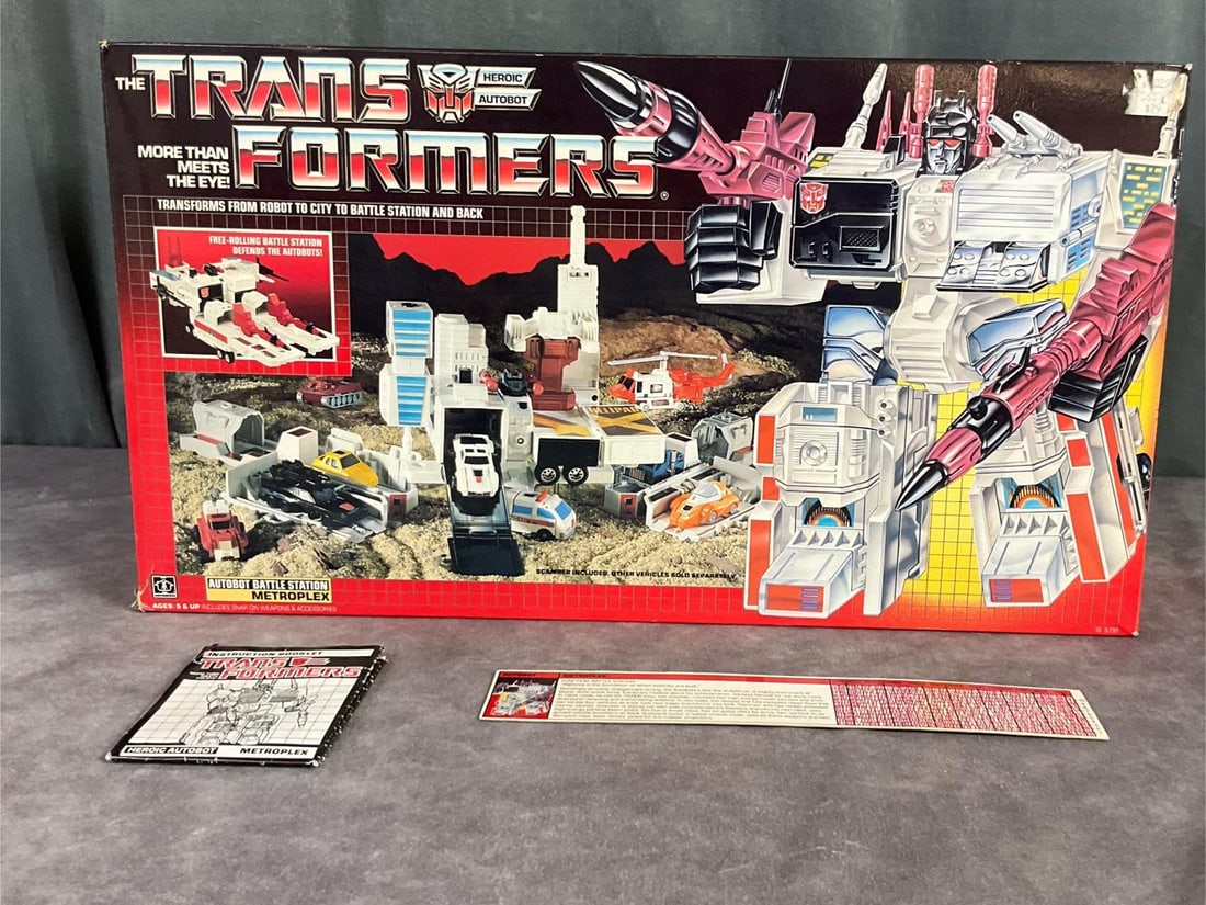 Transformers Heroic Autobot Metroplex: 1985, No. 5791 made by Hasbro. This set is complete with instructions, a spec card, and a code reader. Some play wear to the toy and staining on the styrofoam form, but overall good condition. Box