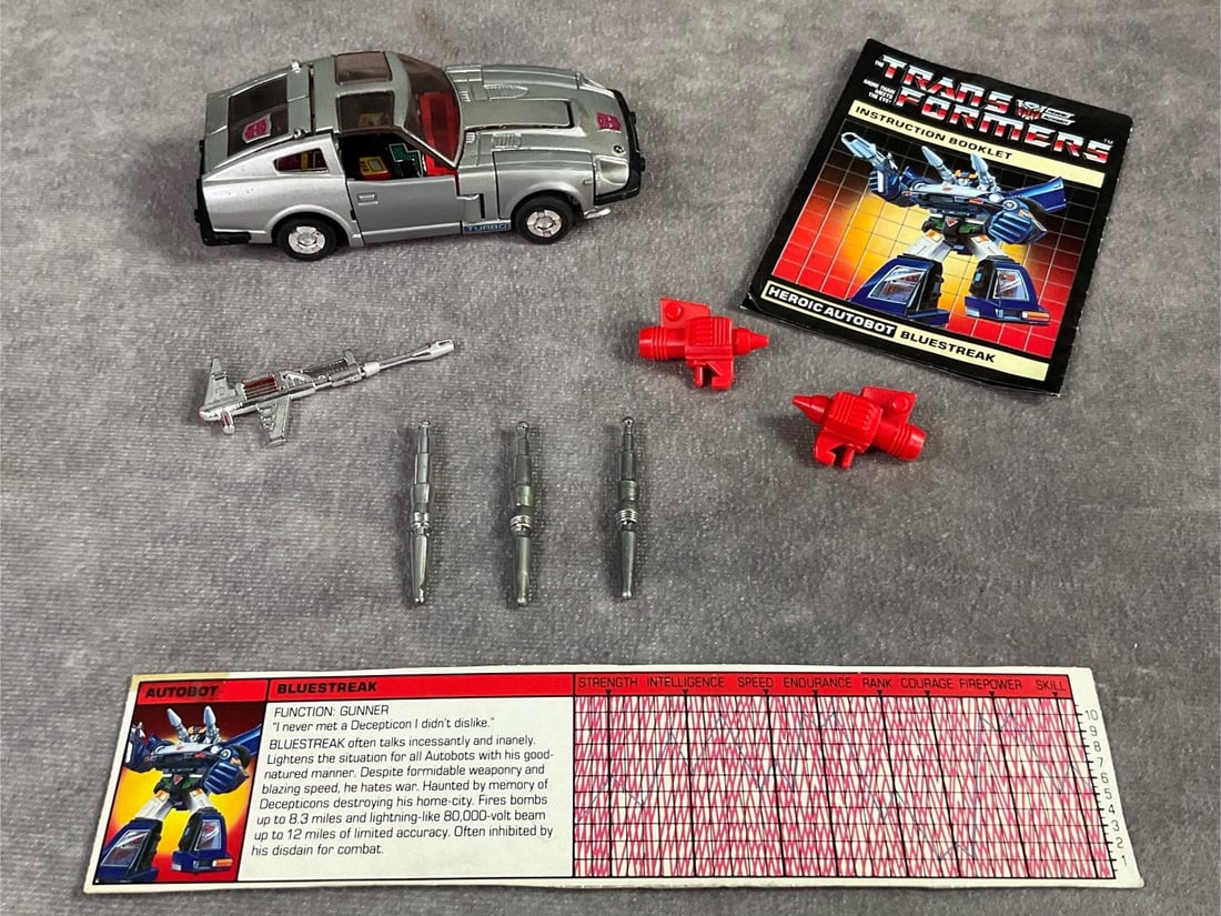 1984 Bluestreak Transformer: Made by Hasbro in Japan. Complete with instruction booklet, catalog, tech spec card, and weapons. Missing decoder. Good condition, but does have minor wear to decals. Measures 4.5 inches long x 1.5 x