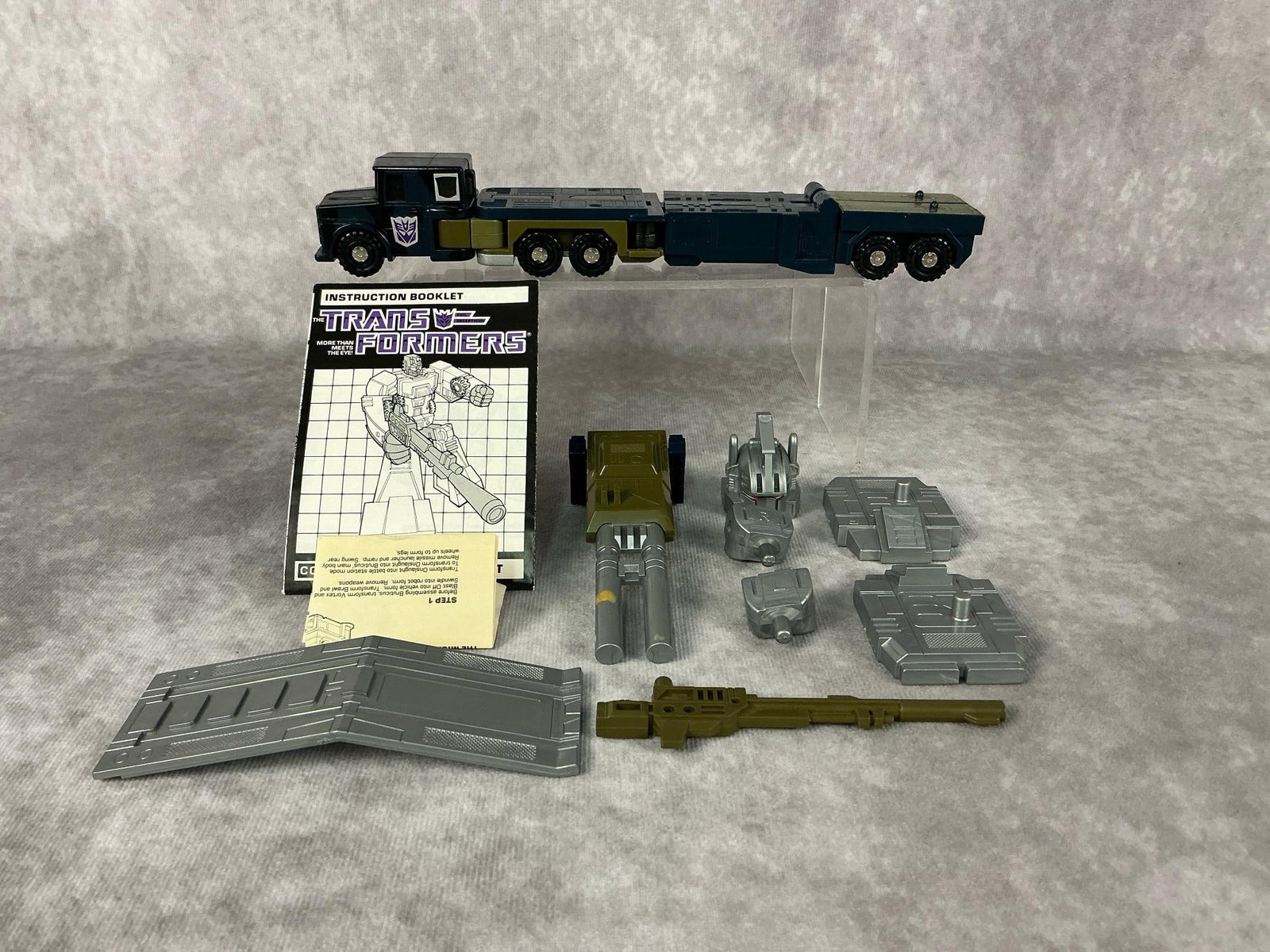 Onslaught Transformer: 1985 Combaticon Onslaught made by Hasbro in Japan. Includes booklet and instructions, helmet, hands, and more accessories. In good condition. Measures 1.75 inches wide x 9 inches long.