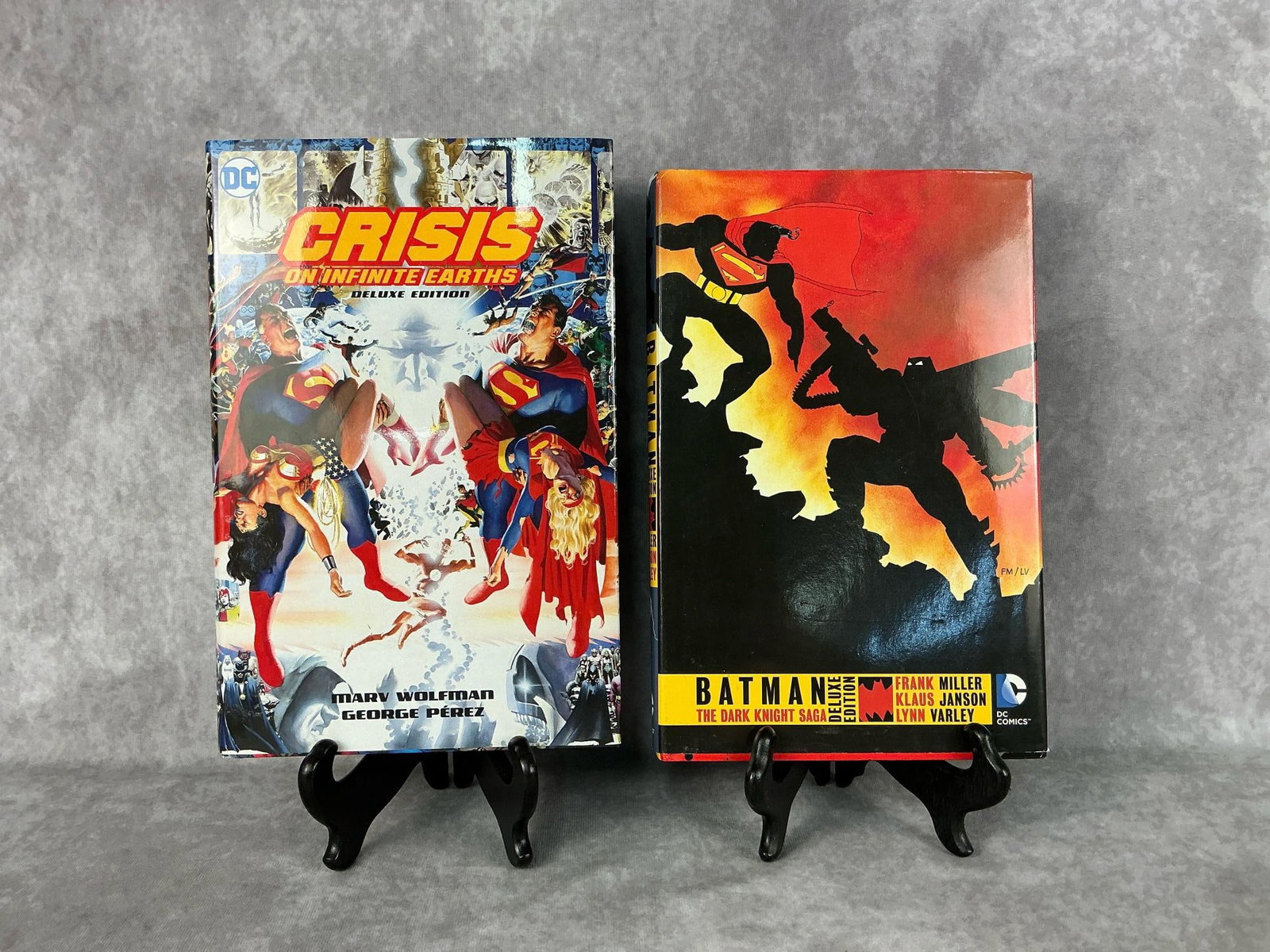 DC Comics Hardback Books: 2015 Crisis on Infinite Earths deluxe edition, and 2015 Batman The Dark Knight Saga deluxe edition. Both with original dust jacksts. In good condition. Largest measures 7.25 inches wide x 1.5 x 11