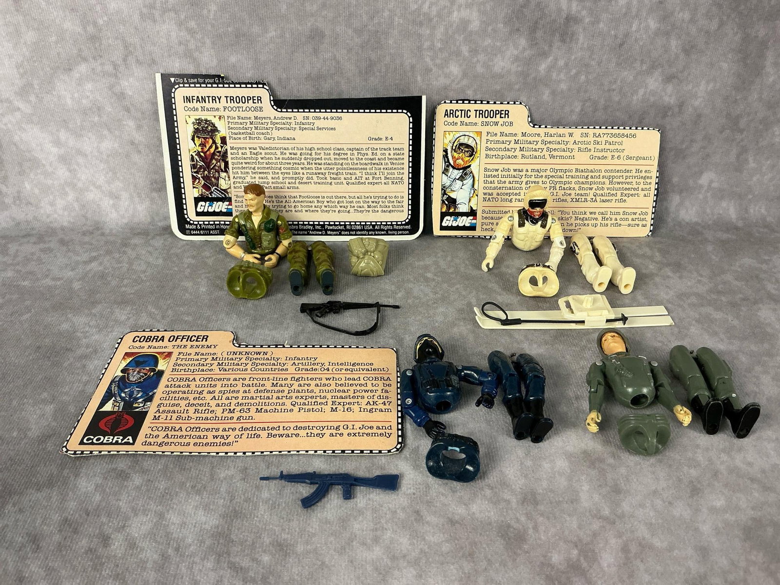 G.I. Joe Action Figures: 1982-1985 G.I. Joe action figures made by Hasbro in Hong Kong. 1982 straight arm Hawk with helmet, 1983 Cobra Officer with file card and gun, 1983 Snow Job with file card and skis and one ski pole,