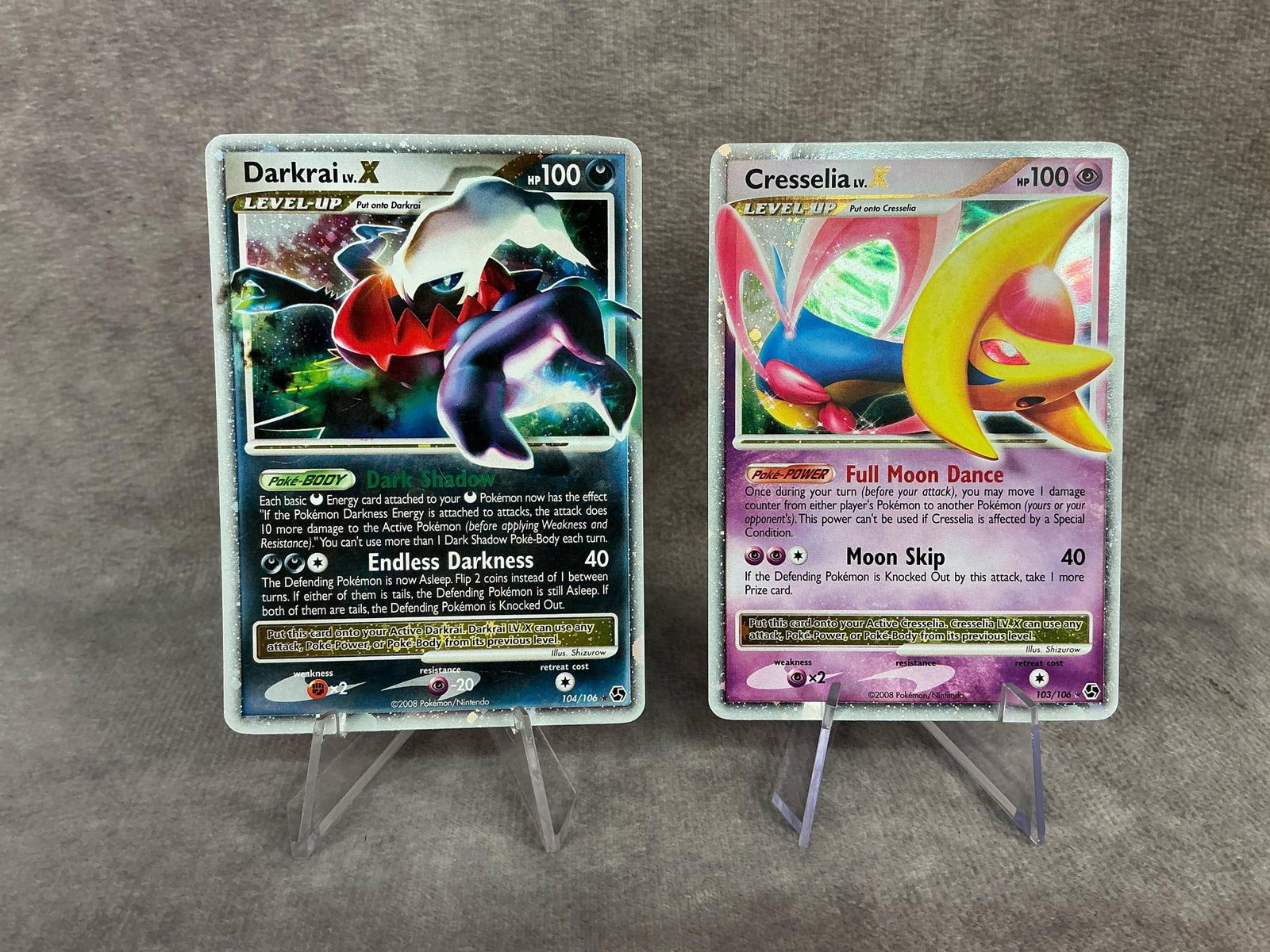 Holographic Pokemon Cards: 2008 Darkrai Level-Up holographic card 104/106, 2008 Cresselia Level-Up holographic card 103/106. Both have slight bowing, otherwise good condition. Each card measures 2.5 inches wide x 3.5 inches