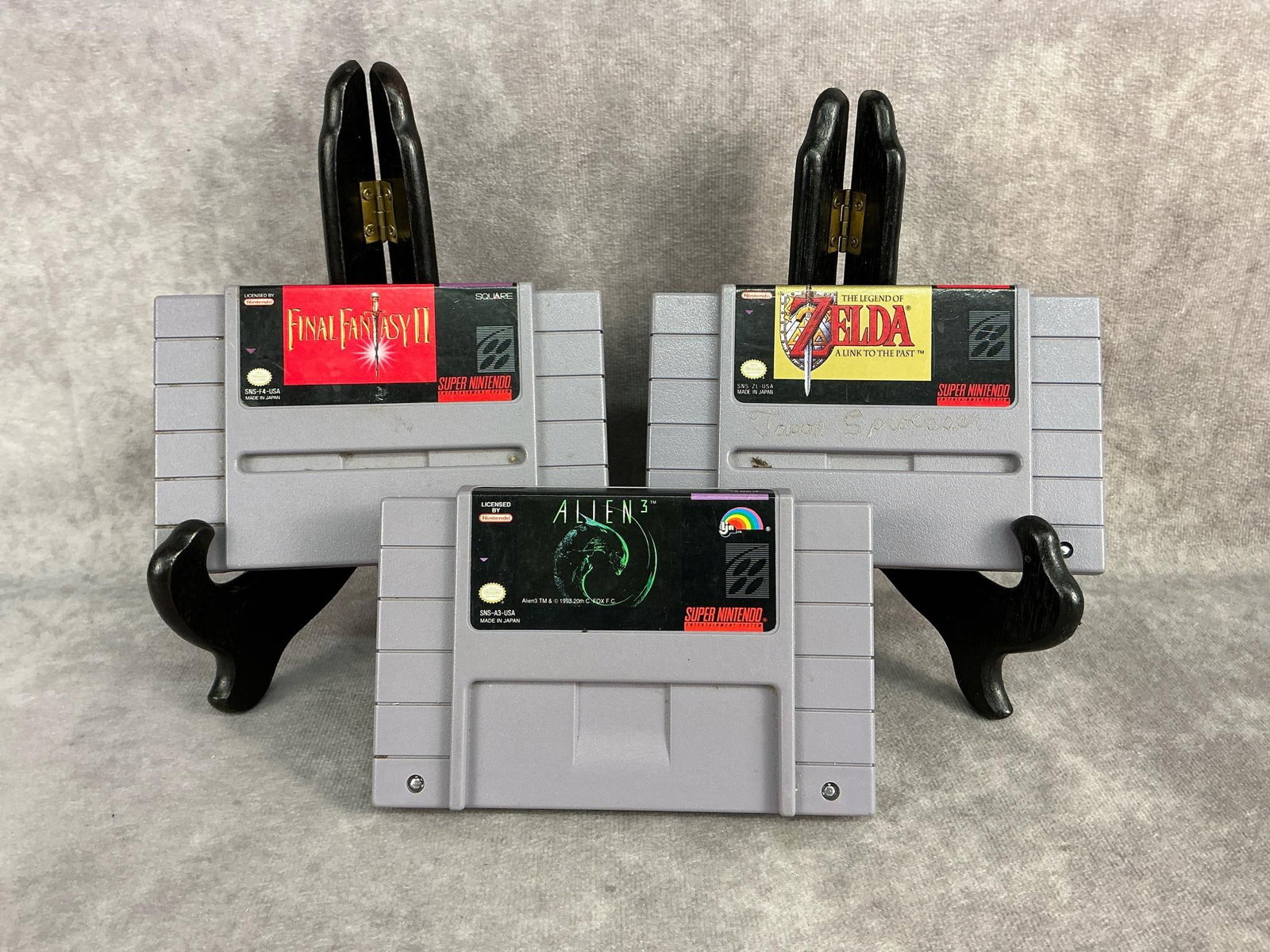 Super Nintendo Games: Three vintage original Super Nintendo games. Includes Zelda, Final Fantasy II, and Alien 3. All are untested, Zelda has a name inscribed on it. Each one measures 5.25 inches wide x 3.25 inches tall.