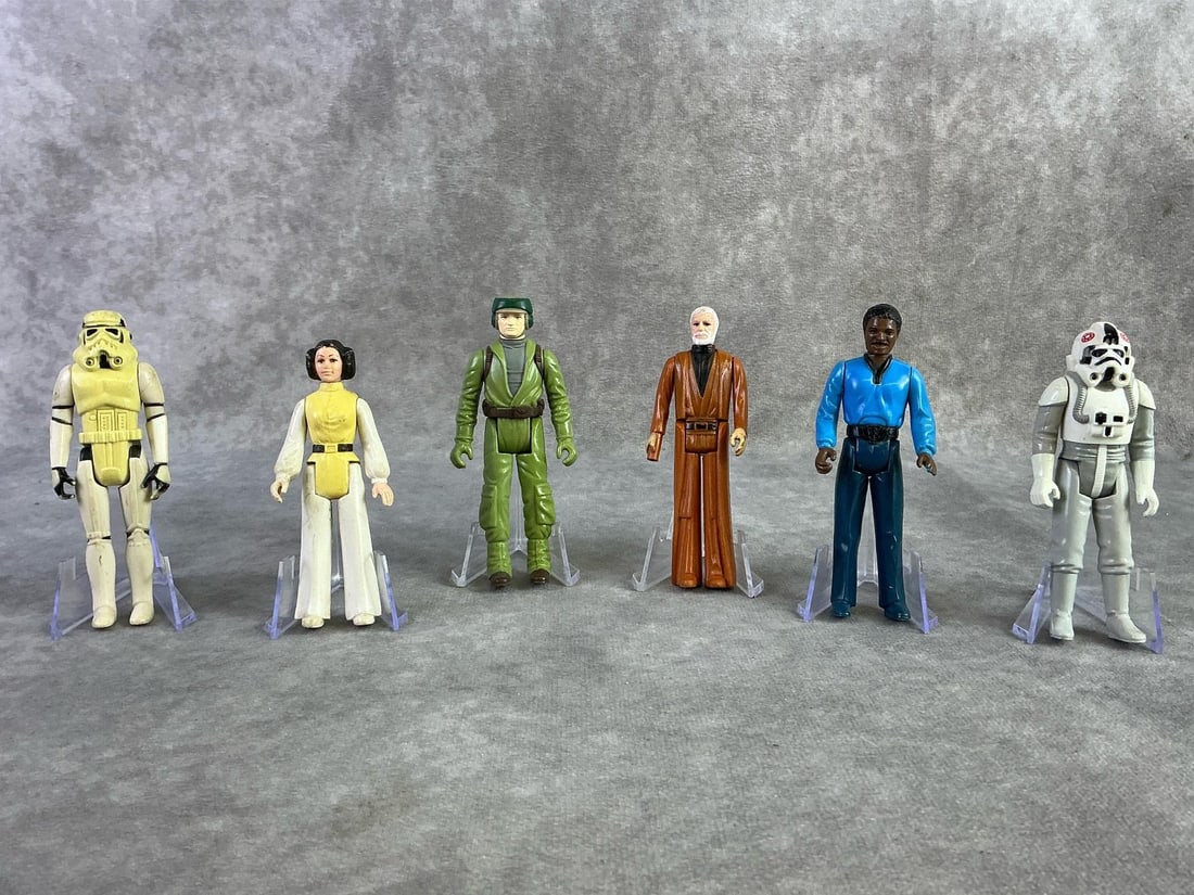 Star Wars Figures: Six Star Wars figures from the 1980s including Leia, Obi Wan, Lando, AT Driver, Stormtrooper, and Rebel Commando. All in fair to good condition with some paint loss and Obi missing his lightsaber. AT
