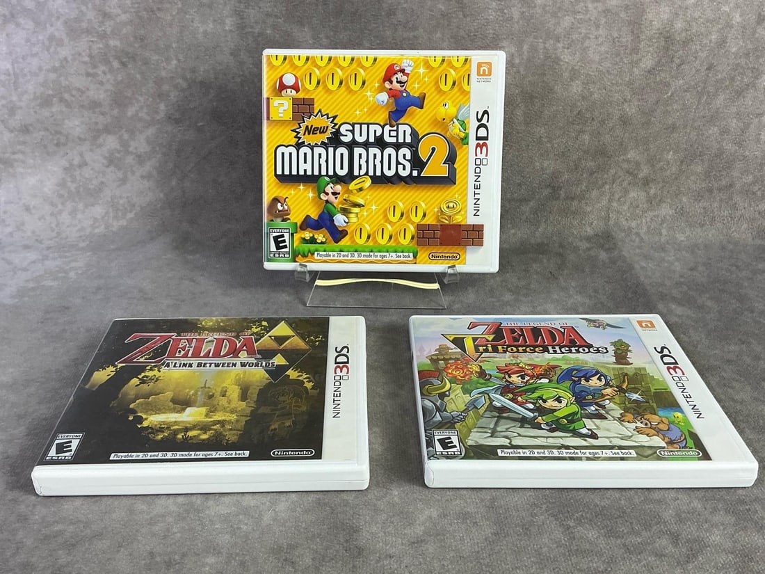 Nintendo 3DS Games: Three Nintendo 3DS games including Super Mario Bros, Zelda A Link Between Worlds, and Zelda Tri Force Heroes. All in good untested condition. Each measures 5.25 inches wide x 4.75 inches tall.