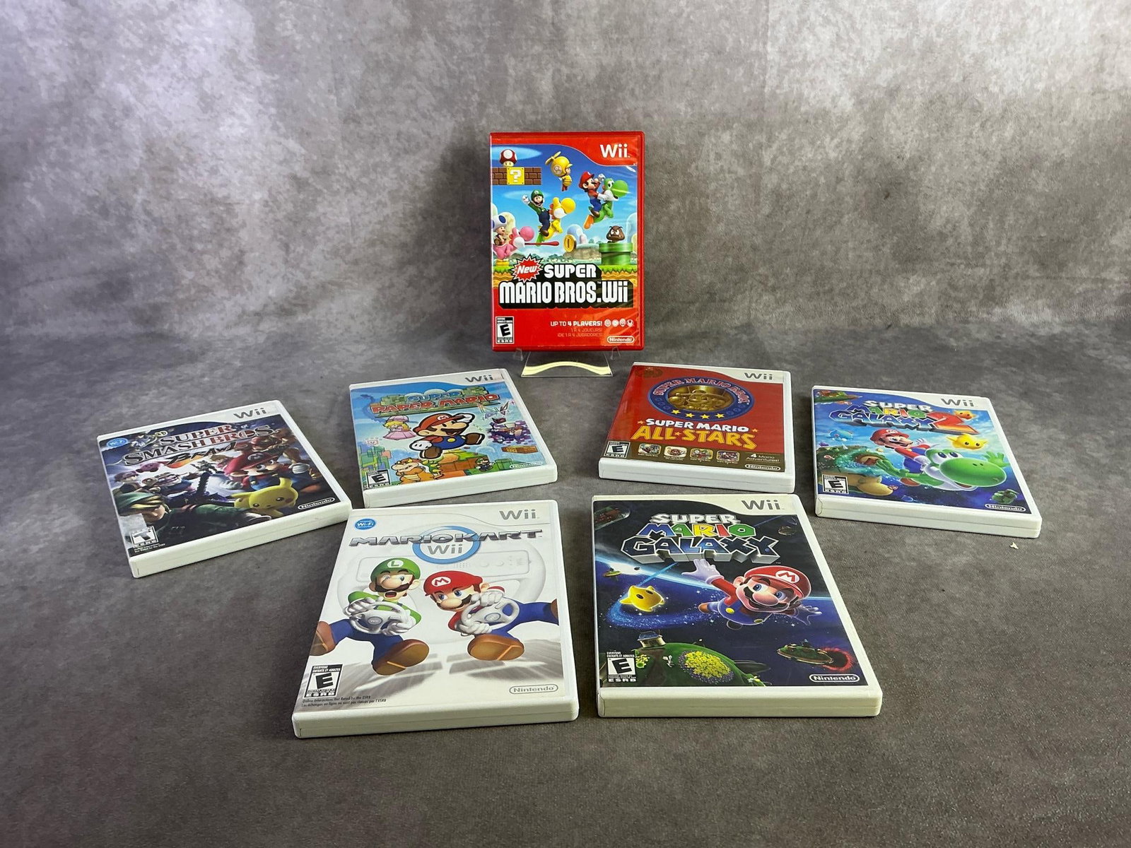 Nintendo Wii Games: Seven Nintendo Wii games including Super Mario Bros, Paper Mario, and more. All in good untested condition. Each measures 5.25 inches wide x 7.5 inches tall.