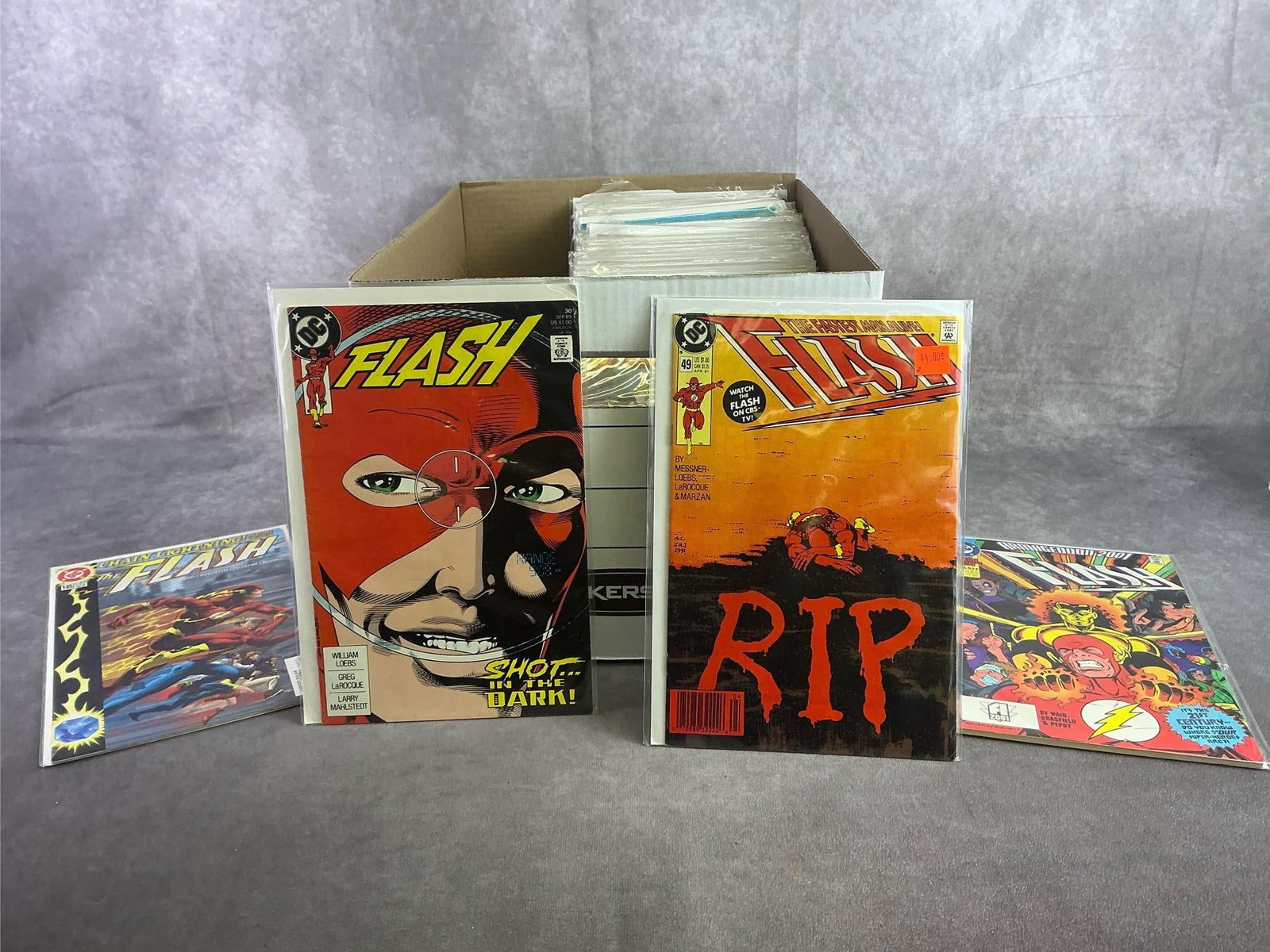 Vintage Comics: Approximately 80 vintage comics including Flash, Thor, Dr. Strange, and more. All in good condition and with plastic sleeve protectors. Box measures 12 inches wide x 15 inches x 10.25 inches tall.