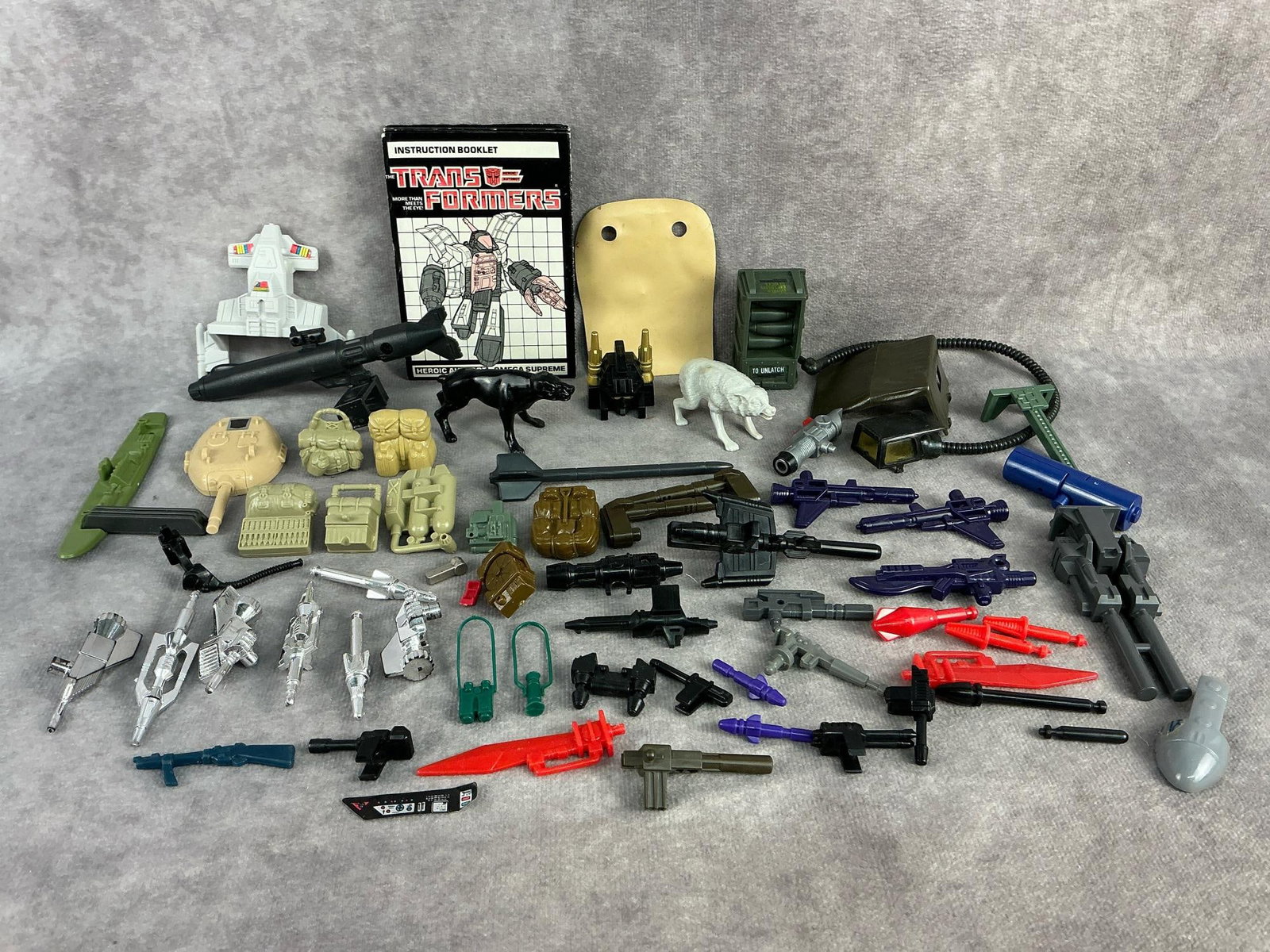 Weapons & Accessories: Vintage action figure accessories and parts for GI Joes, Transformers, and possibly others. Appear to be in good condition. Transformer booklet measures 3 inches wide x 4.25 inches tall.