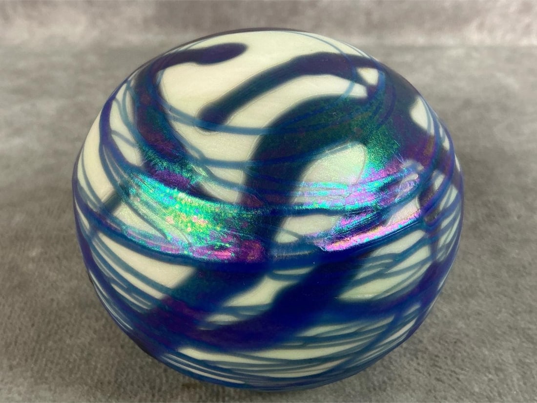 Swirl Paperweight: 1977 white with blue and iridescent swirled paperweight. Signed on bottom by artist Terry Crider. In good condition. Measures 3 inches in diameter x 3 inches tall.