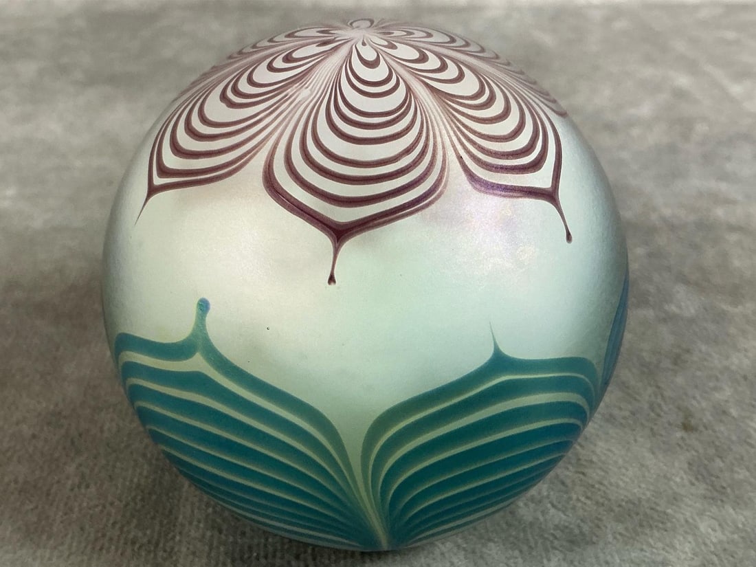 Iridescent Paperweight: 1979 blue and pink hues "pulled feather" design art glass paperweight. Marked Vandermark #51 with floral design. In good condition. Measures 3 inches wide x 3 inches tall.