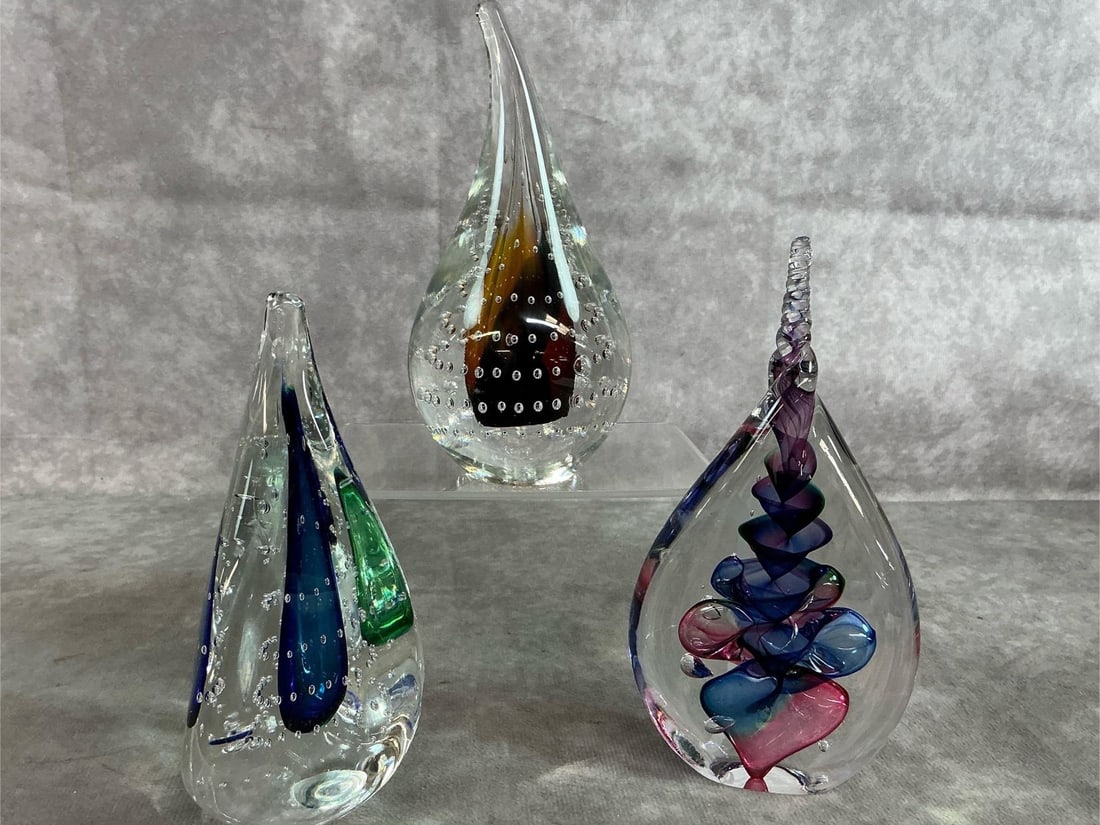 Jablonski Art Glass: Three vintage art glass paperweights by Adam Jablonski. Clear and brown pear shaped, three sided blue and green, and flat tear drop shape with blue and pink design. Artist's initials on bottom. All