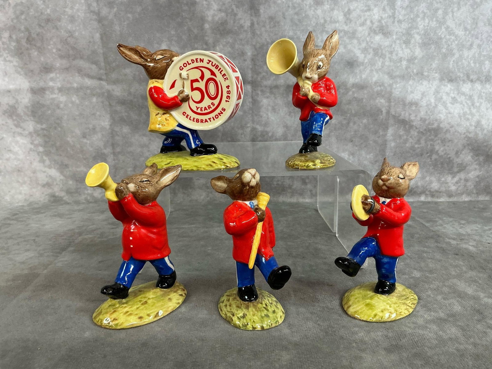 Bunnykins "Oompah Band": Five 1983 Bunnykins figures by Royal Doulton. Golden Jubilee Celebration includes Drummer, Cymbols, Sousaphone, Trumpeter, and Drum Major. In good condition. Drummer measures 3.5 inches wide x 2 x