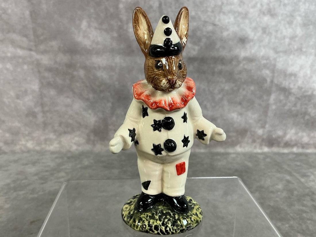 Clown Bunnykins: 1992 Clown Bunnykins by Royal Doulton. Marked DB 128 with ivory, black and pink suit and hat. In good condition. Measures 2.75 inches wide x 1.5 x 4.25 inches tall.