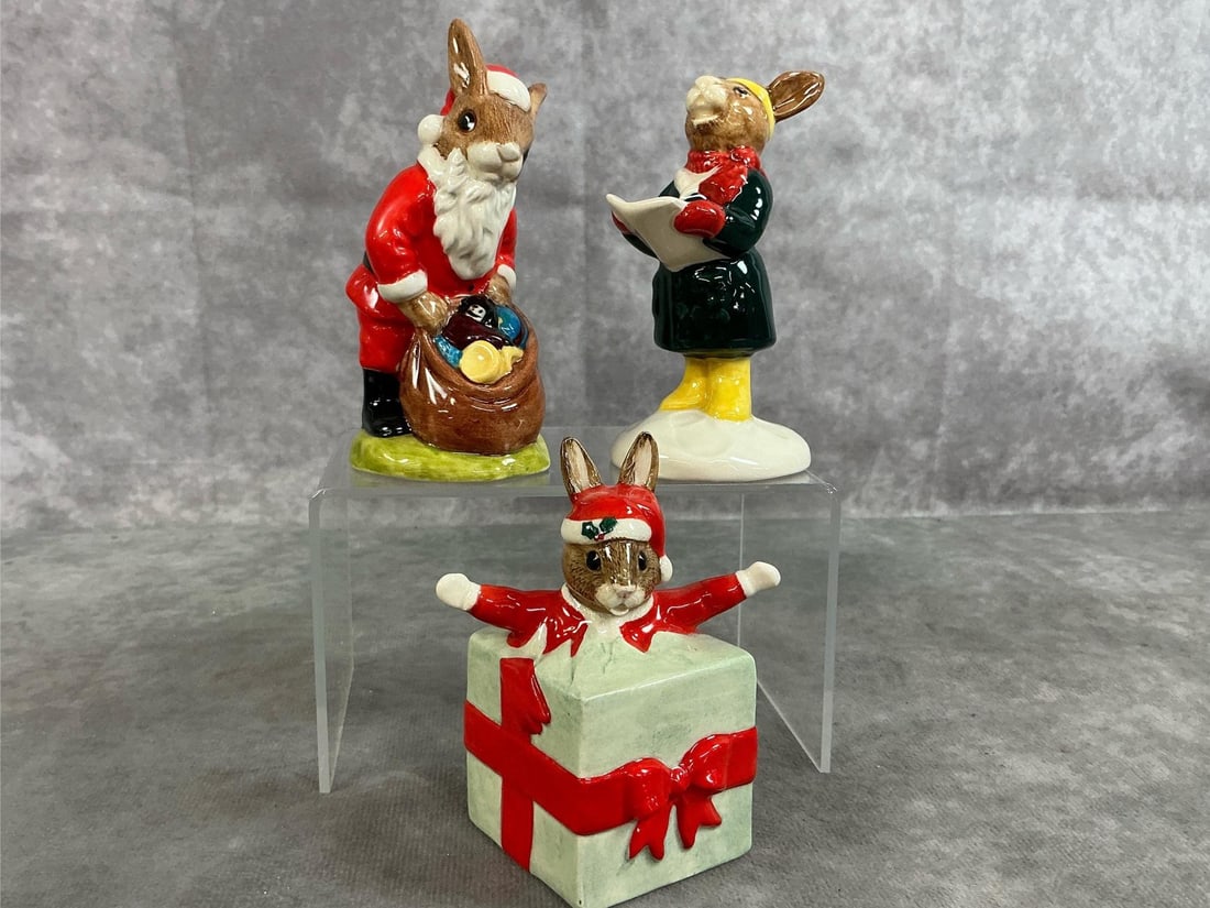 Christmas Time Bunnykins: Three Bunnykins figures from 1981-1986. Royal Doulton figures include "Santa", "Christmas Surprise ", and "Carol Singer". In good condition. Santa measures 2 inches wide x 2 x 4.5 inches tall.