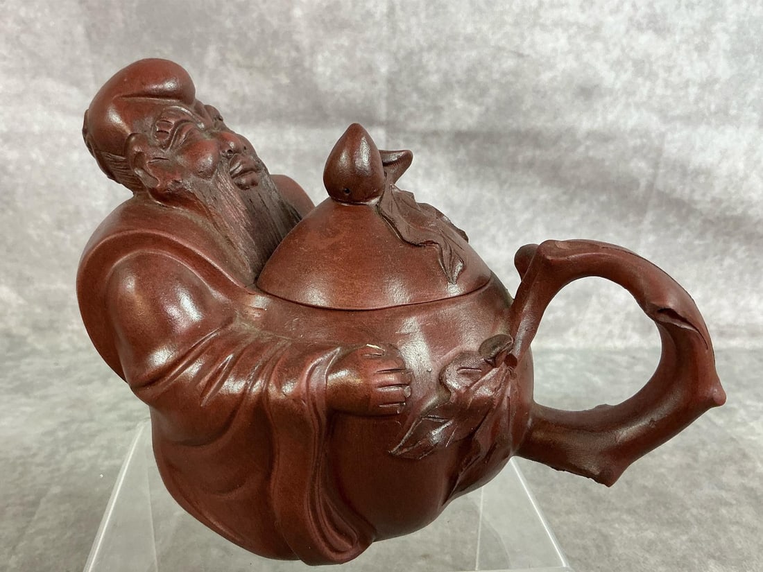 Chinese Zisha Clay Teapot: Vintage Chinese Yixing Zisha clay teapot. Sculpted "wise man" holding a peach. In good condition. Measures 7 inches long x 4 x 4.25 inches tall.