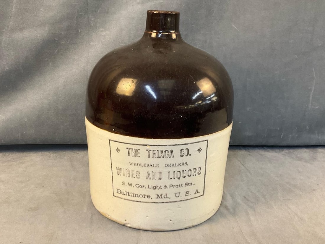 Baltimore Advertising Jug: Late 19th century brown and white two tone stamped advertising jug for "THE TRIACA CO. / WHOLESALE DEALERS / WINES AND LIQUORS / S.W. COR. Light & Pratt Sts., Baltimore, Md., U.S.A." Good condition.