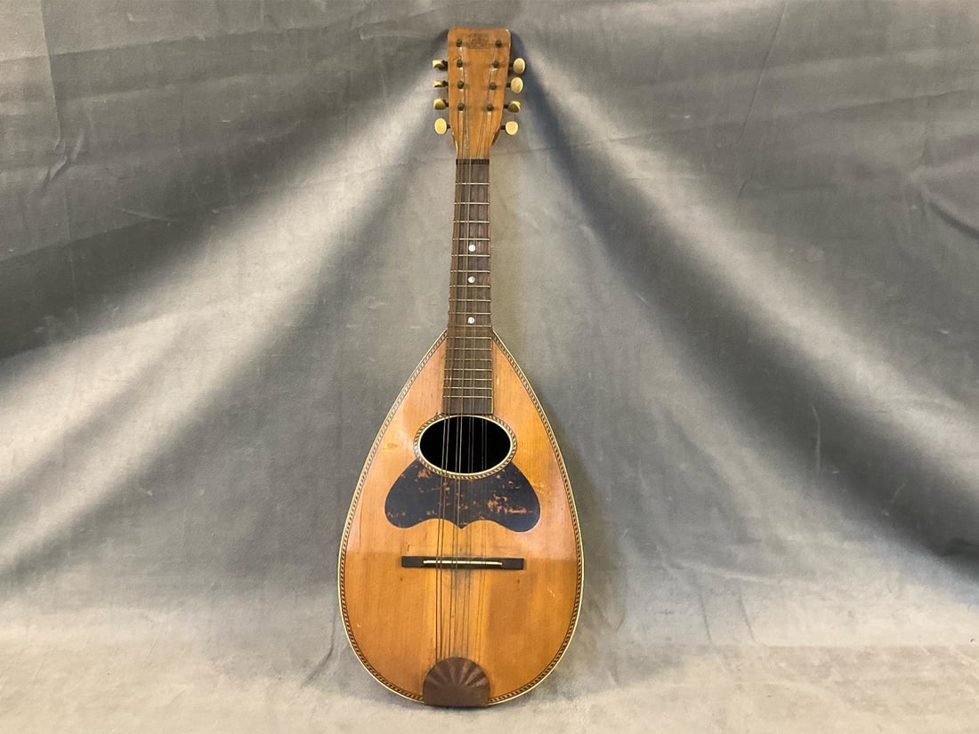 Antique Mandolin: Early 20th century Victoria B & J Warranted mandolin with barber pole inlay and faux tortoiseshell painted pick guard. Paper label to inside. Old repair to neck, otherwise good condition. Measures 24 