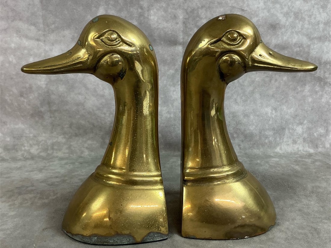 Brass Duck Head Bookends: Pair of mid century heavy brass duck head bookends. Leonard solid brass collection from Korea. Patina present. Each measures 3 inches at base x 6.5 inches tall.