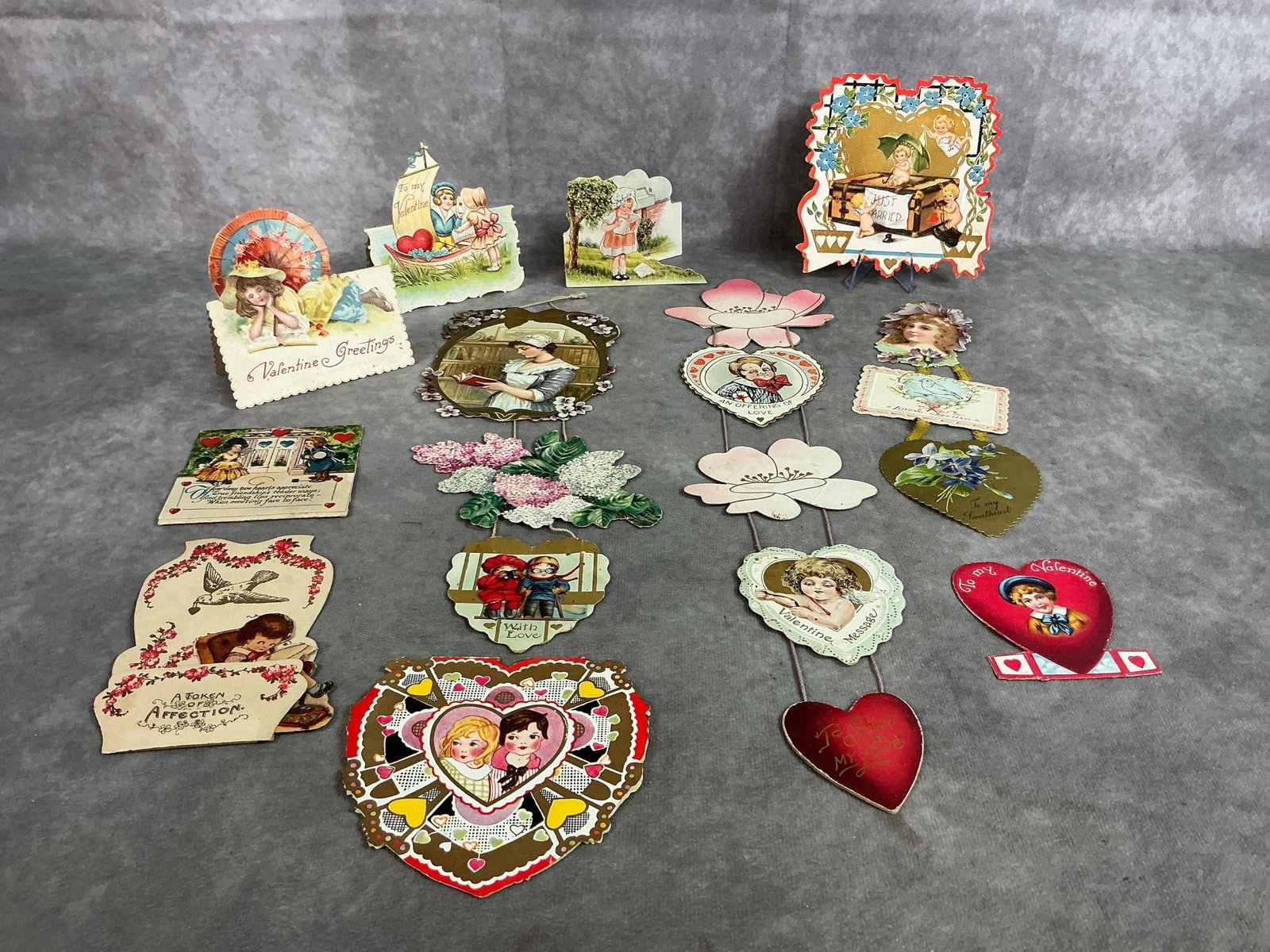Vintage Valentines: Three hanging valentines and eight small valentine cards from 1910's - 1940's. Some are stand alone. Most have writing on back. Pink flowers with cherub and winking boy hanging decoration measures 4