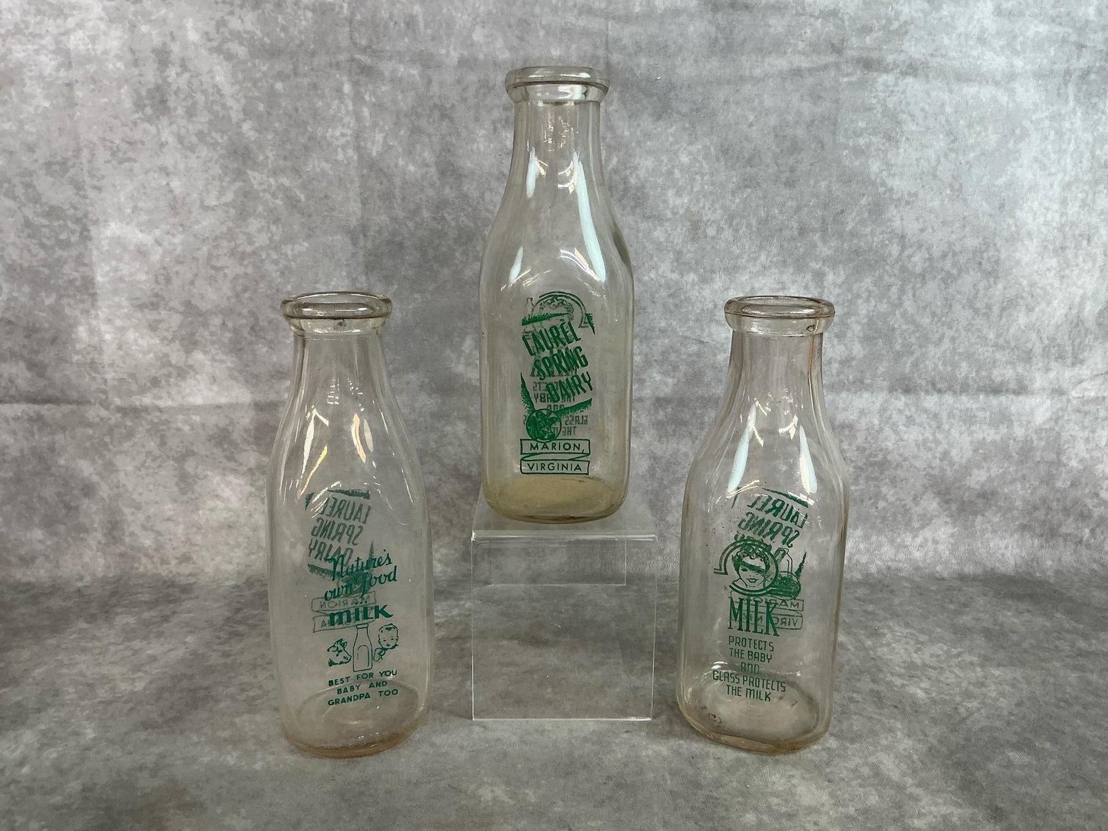 Local Milk Bottles: Three 1930's local interest milk bottles from Marion VA. Each one with pyro logo Local Spring Dairy. Each one quart bottle is marked different on bottom; Duraglass 17 55, number 59 and number 2. Good