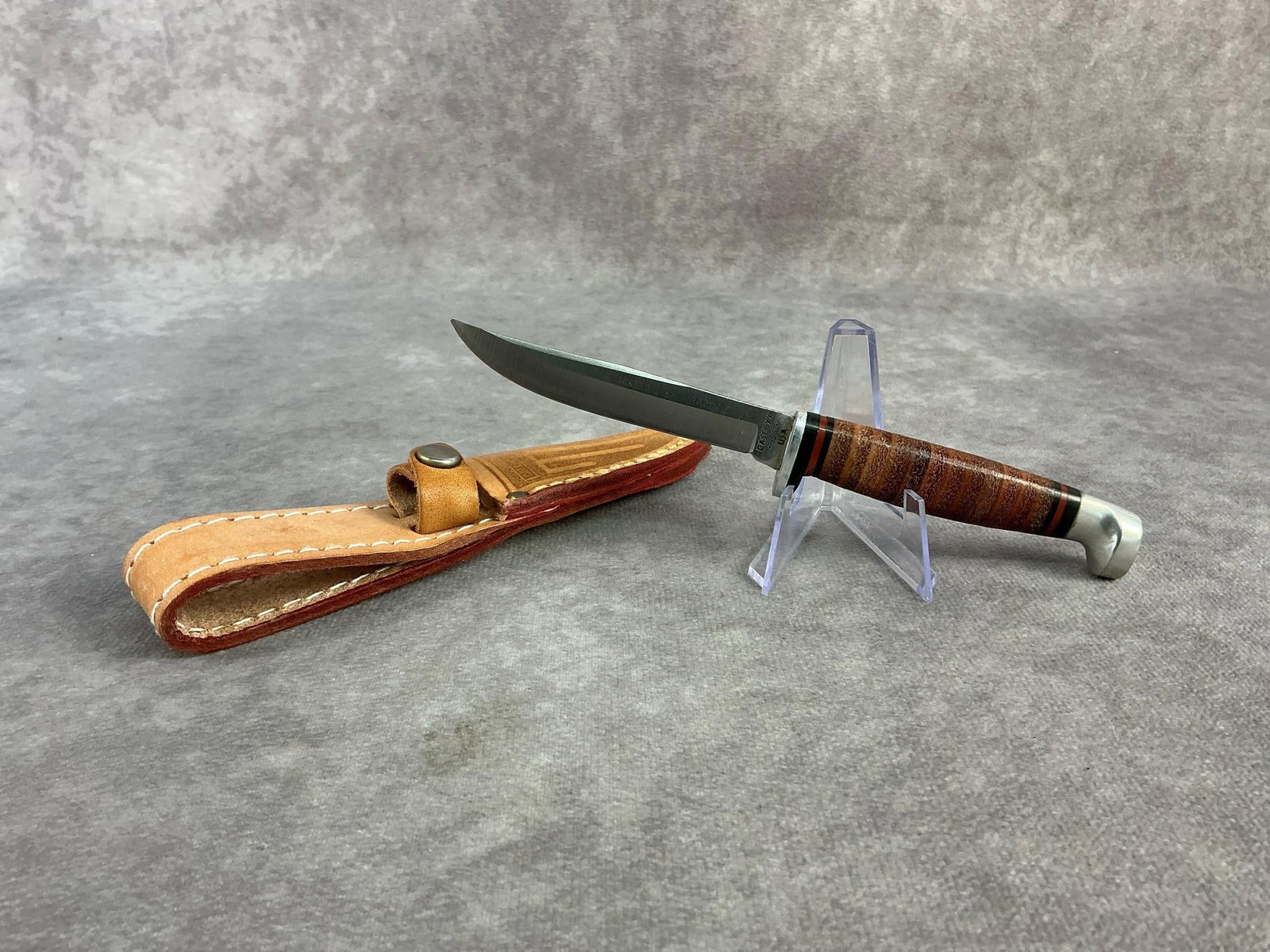 Case XX Knife: Case XX fixed blade knife featuring a stacked leather handle. Minn Finn, patterned M3F, comes with original sheath. Sheath measures 6.75 inches wide x 1.25 inches tall.