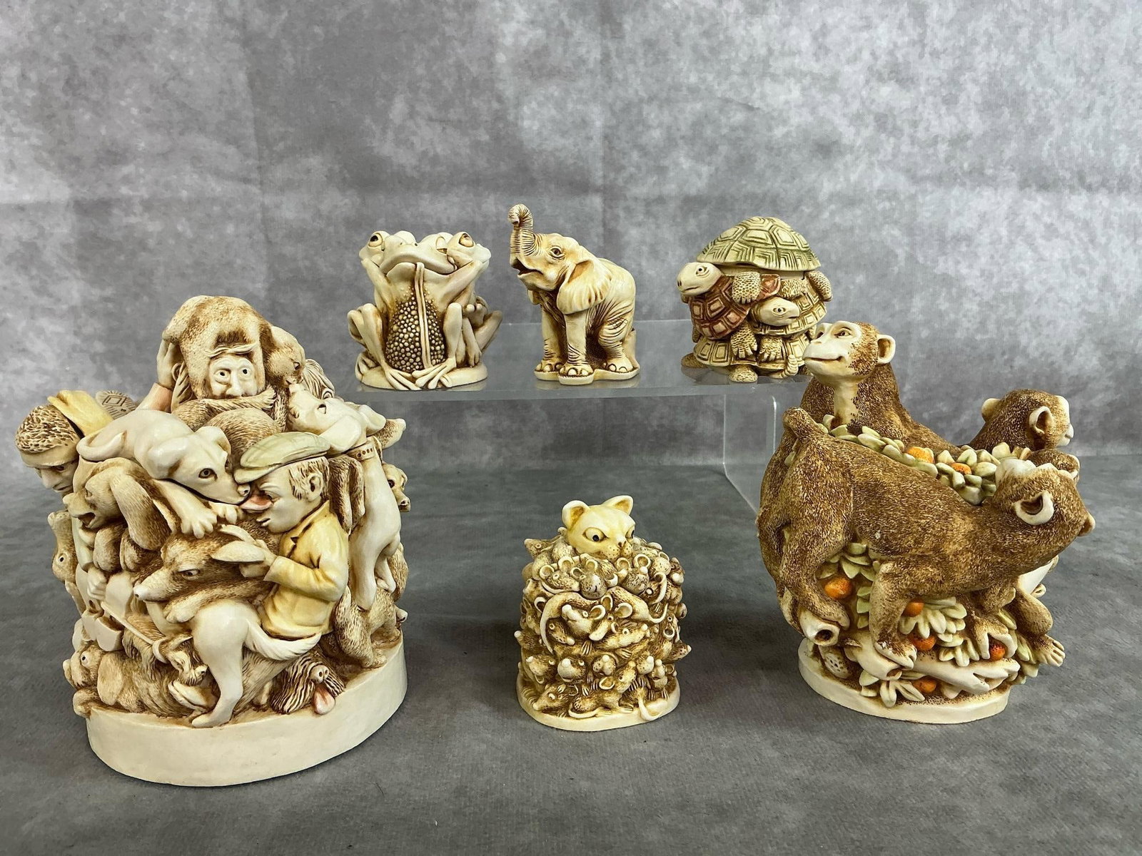 Harmony Kingdom Collectibles: Six 1993-1997 sculptures by Harmony Kingdom. Includes two larger pieces - "Mad Dogs and Englishmen" and "Family Reunion " monkeys. Smaller sculptures include frogs, turtles, an elephant, and cat and m