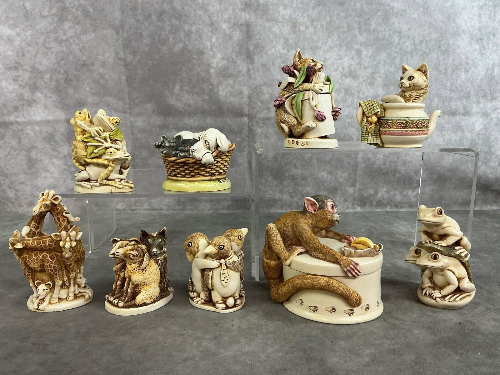 Harmony Kingdom Collection: Nine 1999-2003 Harmony Kingdom's collectibles. Includes "Koko's Treat" 2003 monkey, "Pecking Order" cat and dog in basket, and two small cat sculptures. Also, frogs, penguins, giraffes, and sheep. All