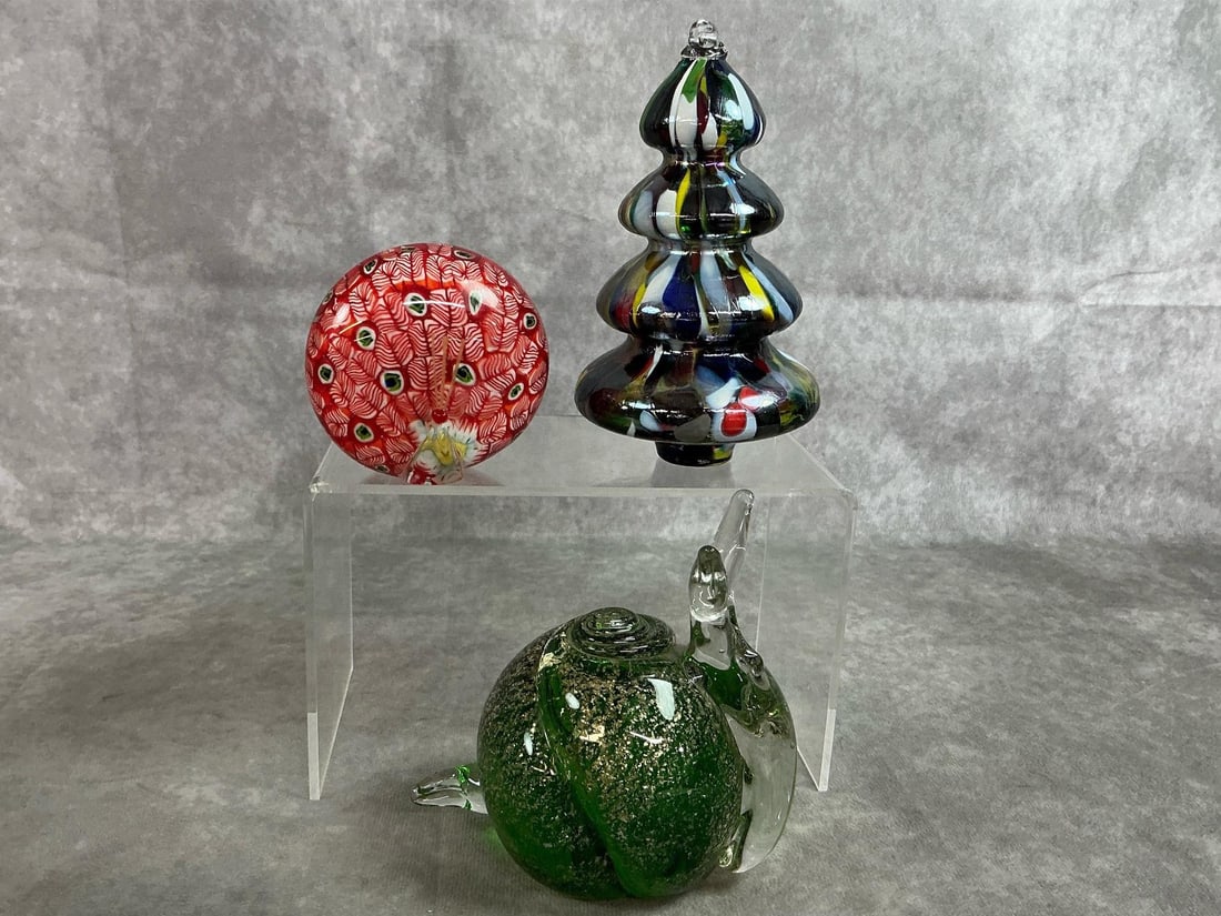 Unique Art Glass: Three vintage art glass pieces. Green snail with gold flecks, multi colored Christmas tree, and red feather patterned peacock. In good condition. Tree measures 3.75 inches wide x 5.5 inches tall.
