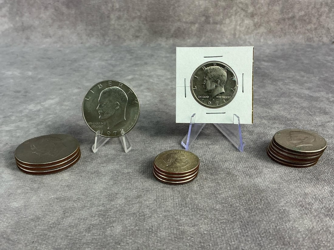 Assorted US Coinage: Four Ikes, seven Kennedy halves, and four Susan B. Anthony dollars. All in good circulated condition. Ikes measures 1.5 inches in diameter.