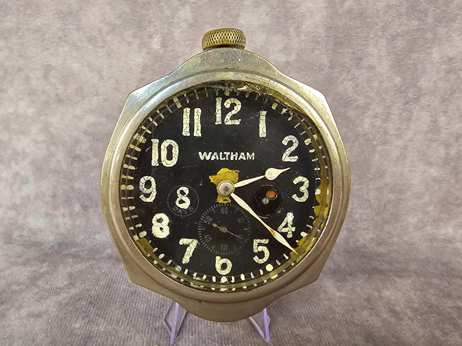 Waltham Car Clock: 1910s Waltham eight day, seven jewel, car clock in working condition. Paint on dial is cracking, wear to metal. Measures 3.25 inches x 3.75 inches tall.