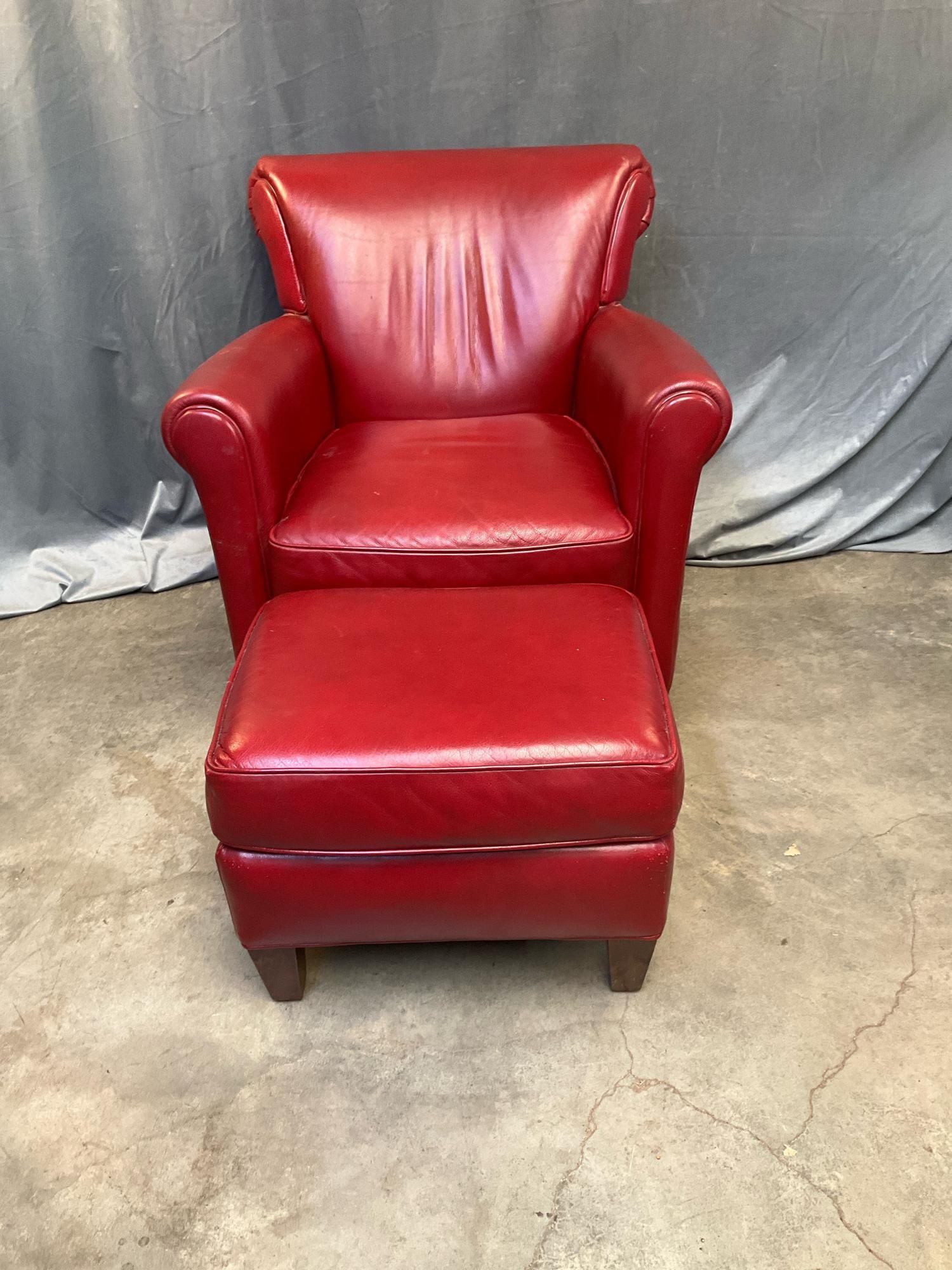 Leather Club Chair: Contemporary red leather club chair and footstool. Scratches to back and sides, otherwise good condition. Measures 33.5 inches wide x 32 x 35 inches tall.
