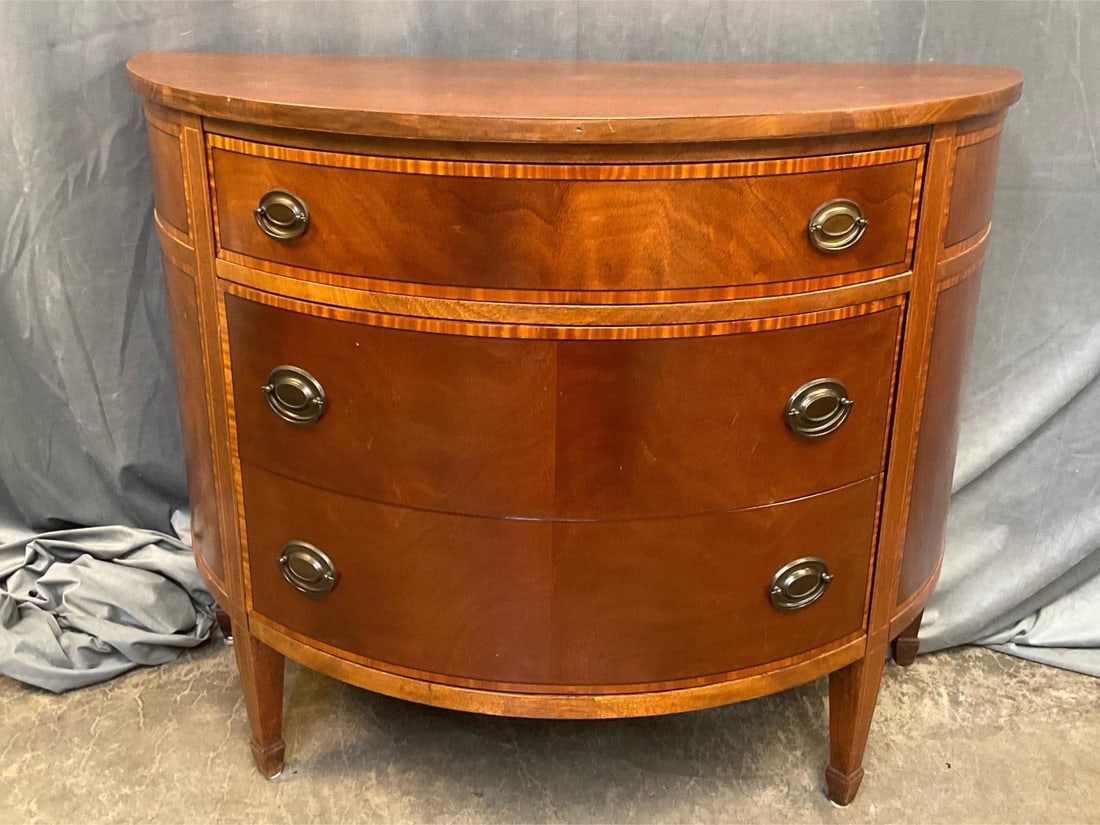 Demilune Chest of Drawers: Late 20th century Hepplewhite style mahogany demilune three drawer chest with banded and line inlay and spade feet. Good condition. Measures 42.25 inches wide x 20 x 33.5 inches tall.