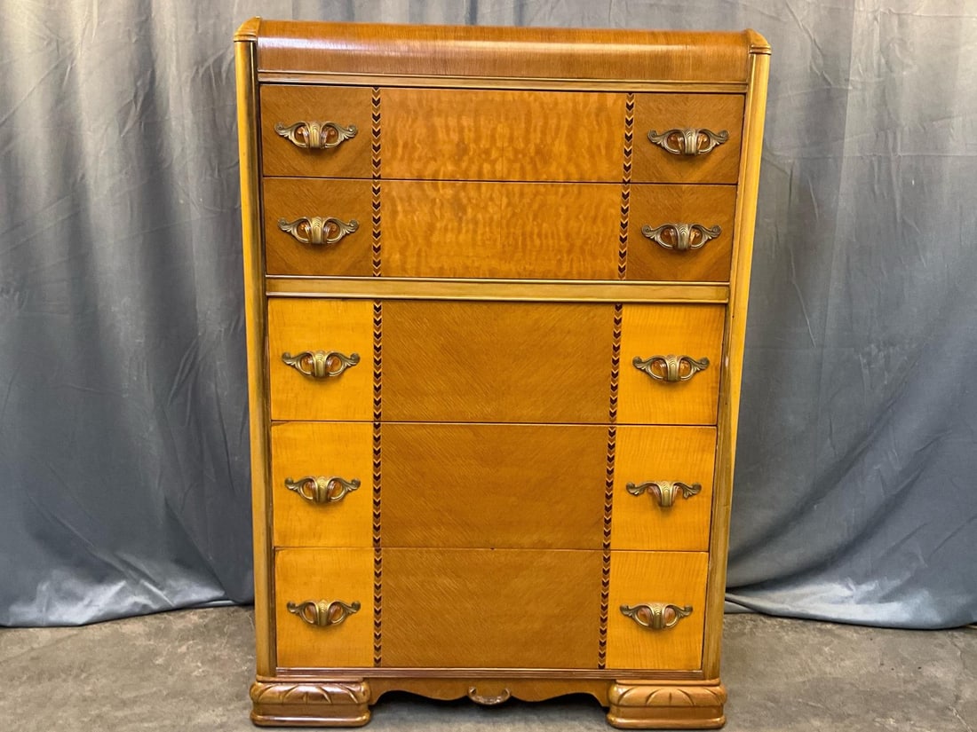 Art Deco Chest of Drawers: Early 20th century Art Deco waterfall design style high chest of five drawers. Oak and maple book-matched veneer front, faux brass and Bakelite handles with chevron banded inlay. One drawer handle cra