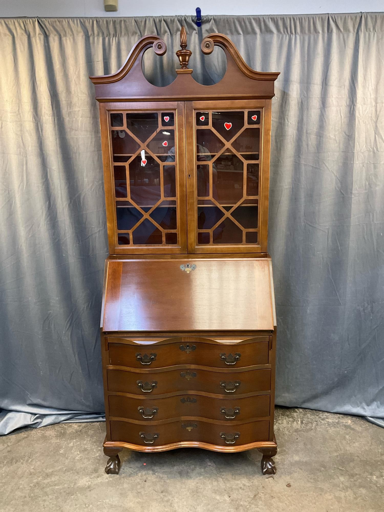 Secretary Desk: Late 20th century Maddox Furniture Company Chippendale Style walnut two piece secretary fall front desk. Serpentine front, scrolled pediment with flame finial, ball and claw feet and brass batwing har
