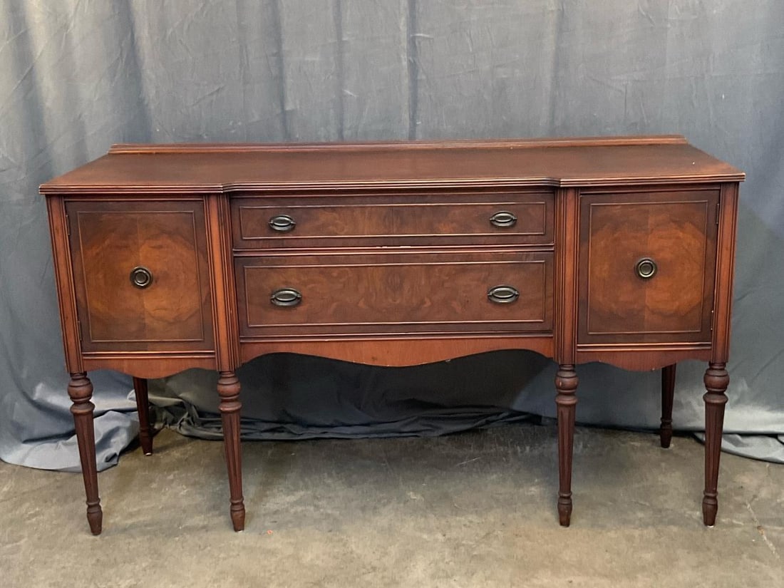 Sheraton Style Sideboard: Mid-20th century Sheraton style burled walnut sideboard/buffet. Expected wear to finish, otherwise good condition. Measures 65.5 inches wide x 20 x 36.75 inches tall.