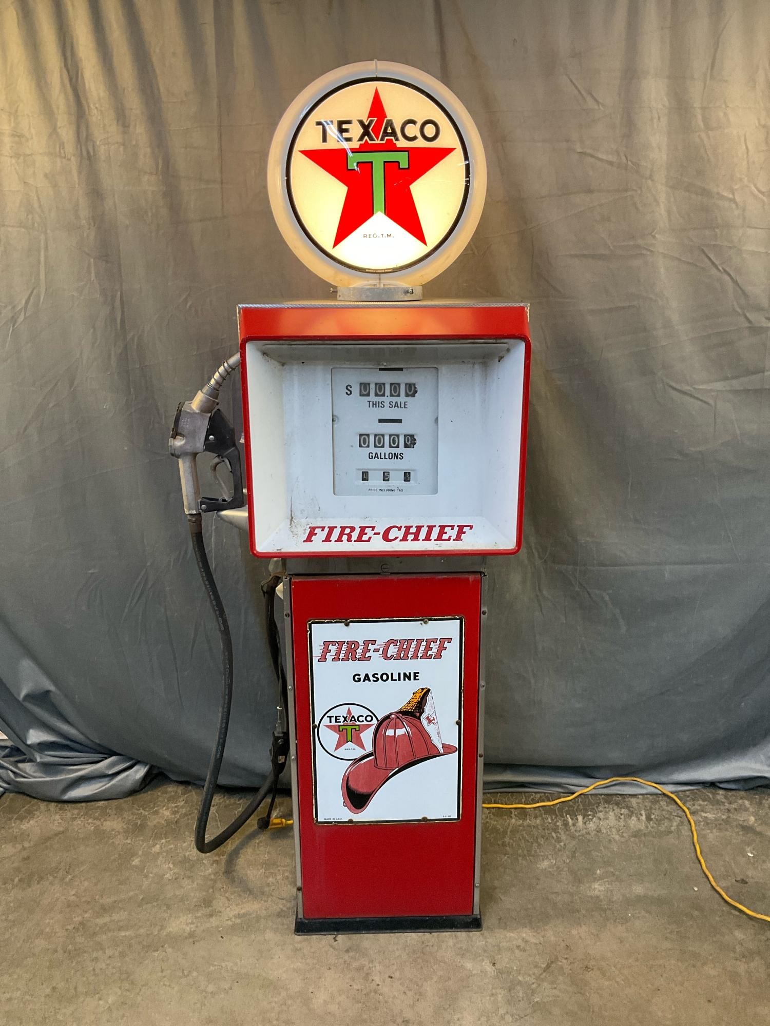 Texaco Gas Pump: 1960's electric Texaco Fire Chief gasoline pump with working lighted plastic globe and light timer. Surface rust areas, missing original glass globe, paint fading with some flaking. Measures 21
