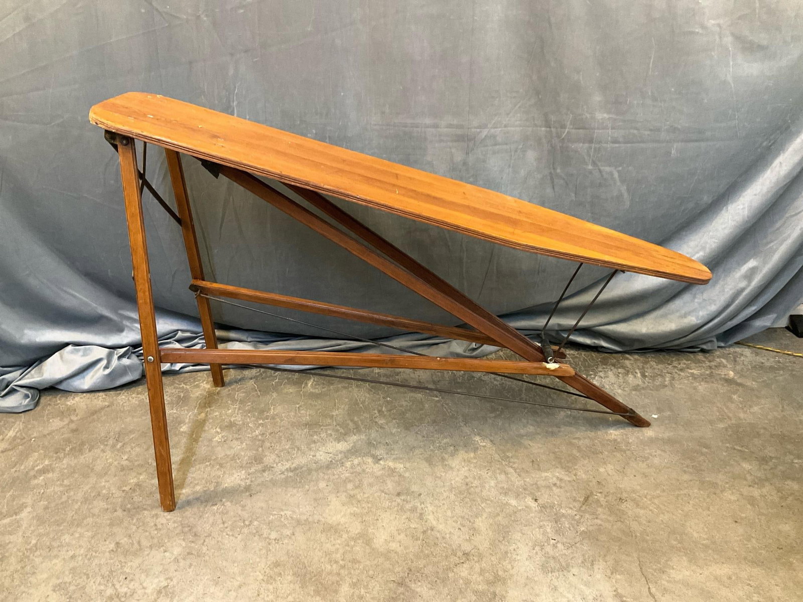Wooden Ironing Board: Early 20th century pine folding ironing board. Missing support (not level when unfolded), wood filler added to one support. Measures 54 inches wide x 14.5 x 32.25 inches tall.