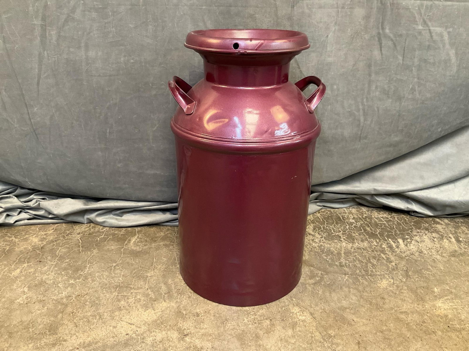 Milk Can: Mid-20th century repainted purple dairy milk can. Good condition. Measures 14 inches wide x 23.5 inches tall.