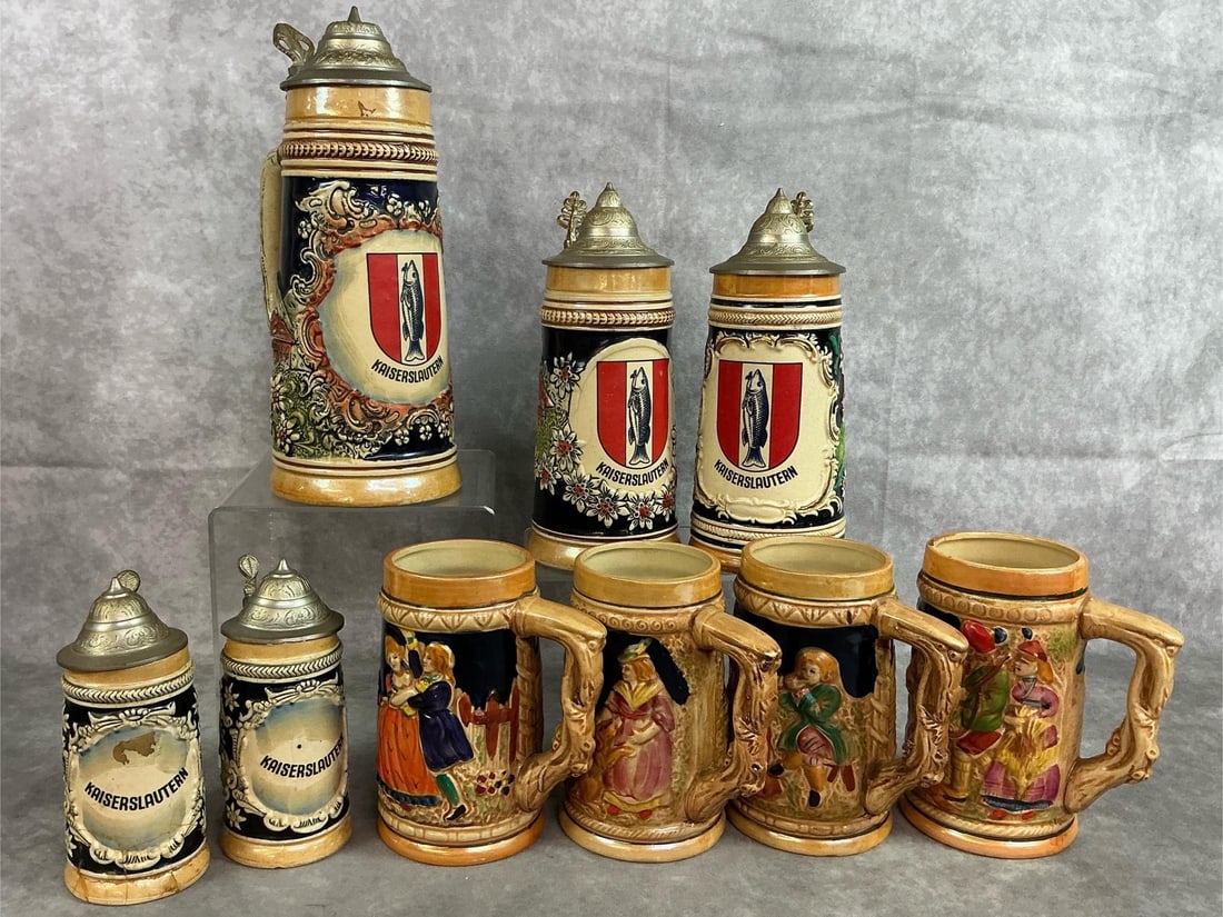 German Beer Steins & Mugs: Five beer steins and 4 mugs from early to mid 1900's. German steins are ceramic with lids of pewter and raised relief details, featuring Coat of Arms Kaiserslautern. Also four mugs with German tavern