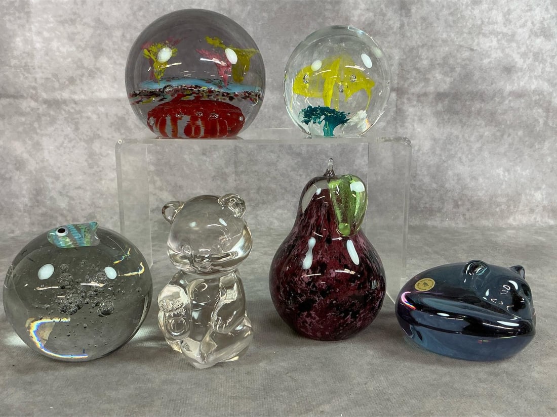 Variety of Art Glass: Six pieces of vintage art glass paperweights. Includes Merry Christmas, multi-colored paperweight, clear orb with fish, clear glass bear, purple apple, blue cat, and yellow bloom in clear glass.