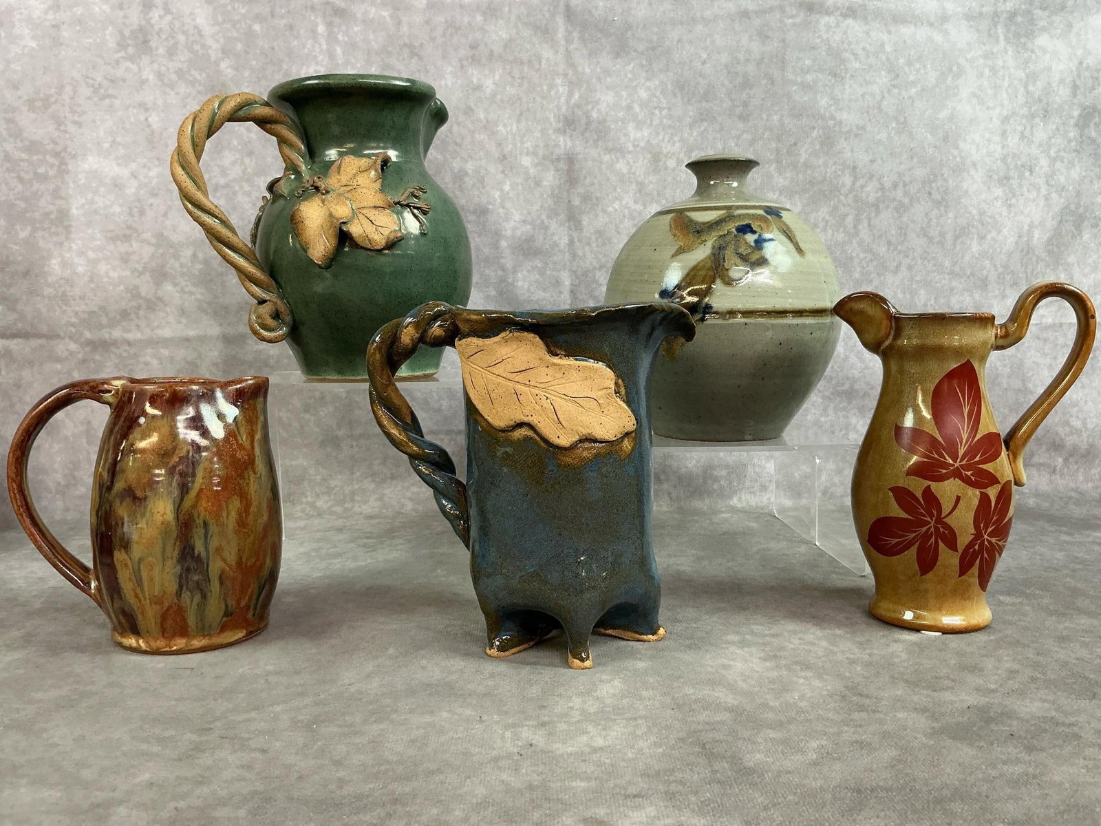 Studio Pottery: Five mid 1900's to modern pottery. Two pieces of North Carolina pottery, grey glazed stoneware vase, fired small brown swirl pitcher and Autumn foliage small pitcher. Initials marked on bottom of most