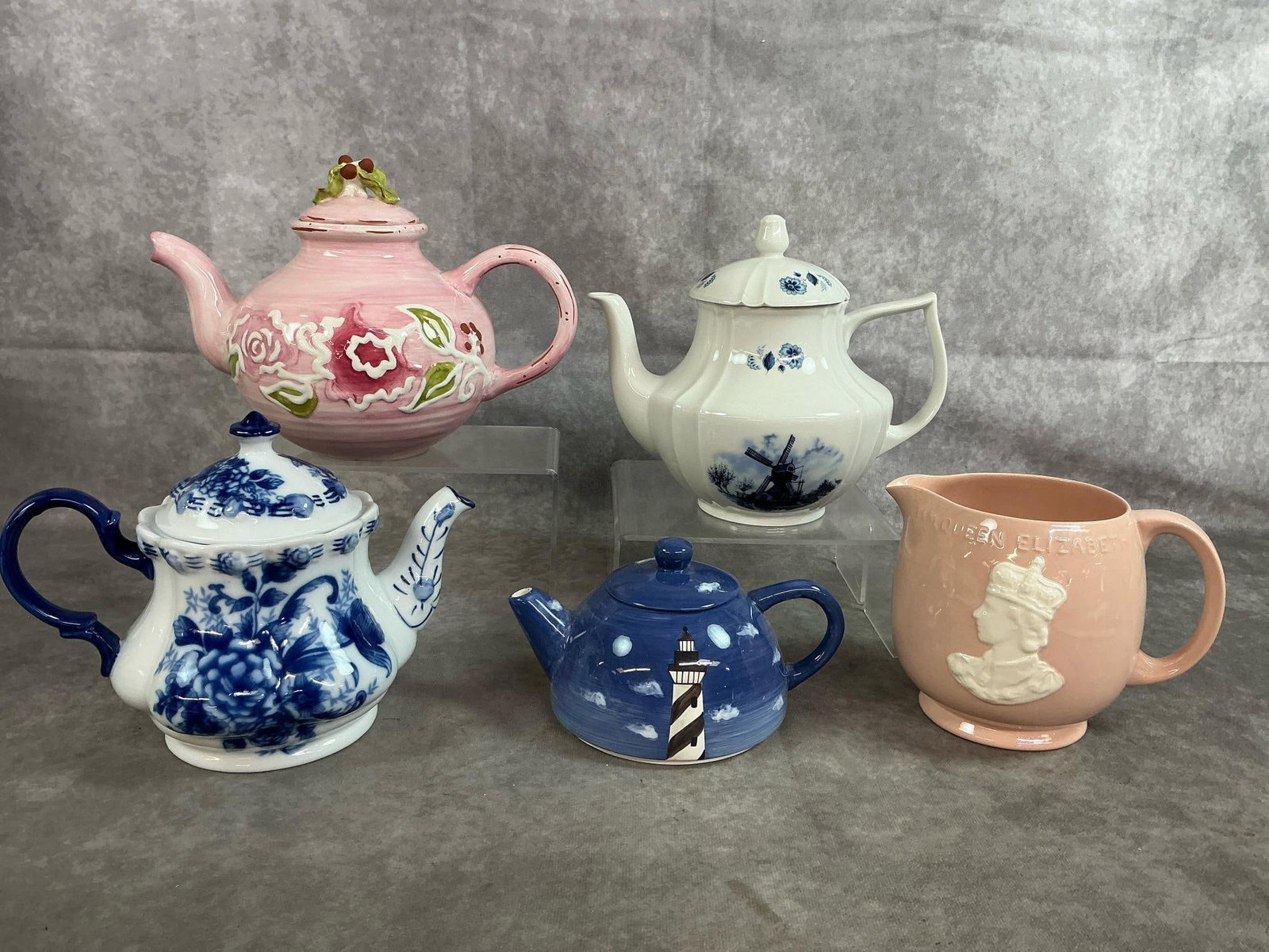 Teapots & Pitcher: Five late 1900's to 2000's teapots and pitcher. Pale pink ceramic pitcher commemorates 1953 Coronation of Queen Elizabeth II. Holland Delft Teapot with windmill, plus three more teapots. In good condi