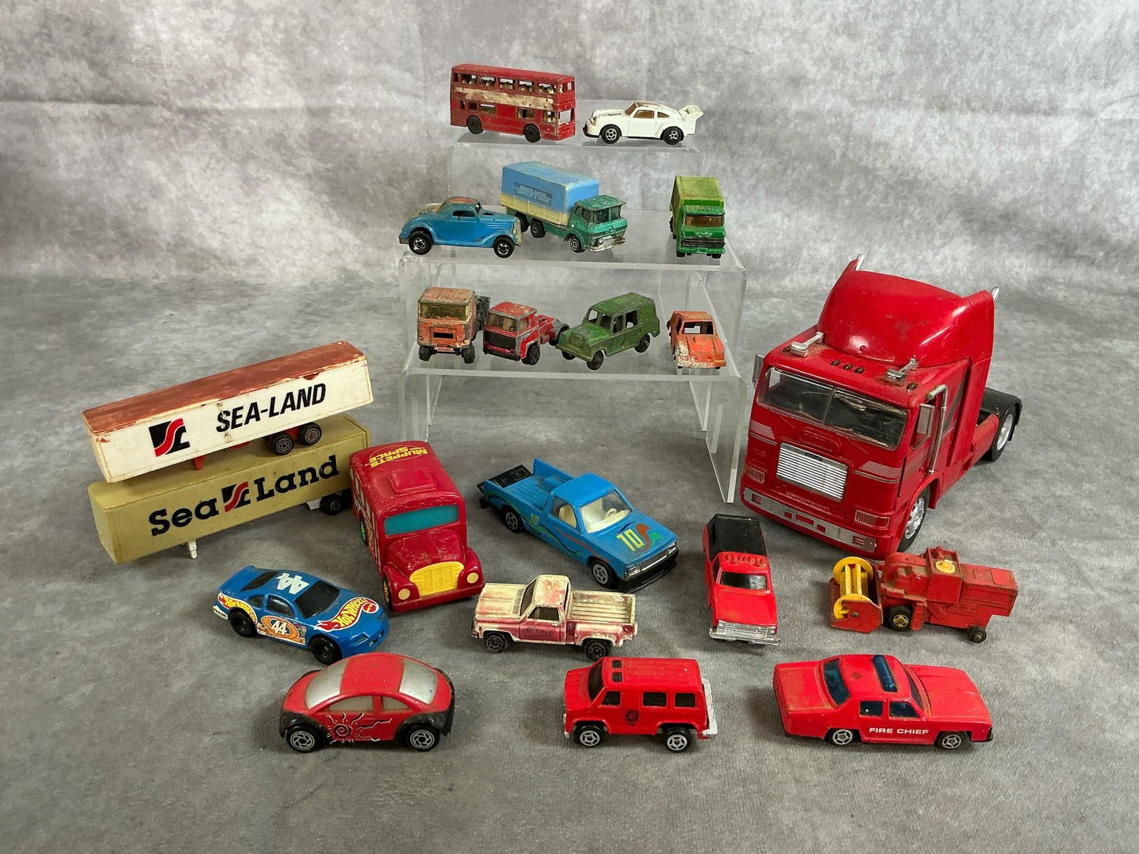 Vintage Play Cars & Trucks: Twenty mid to late 1900's die cast cars and trucks. Includes large Freightliner Cab, red double decker Londoner bus, fire and rescue vehicles, and more. Rust present. Freightliner measures 3.25 inches